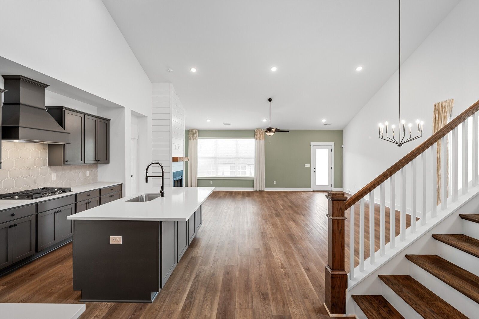 Modern open-concept kitchen with dark cabinets, quartz island, and hardwood floors in Davidson Homes The Ridgeport, Gallatin TN