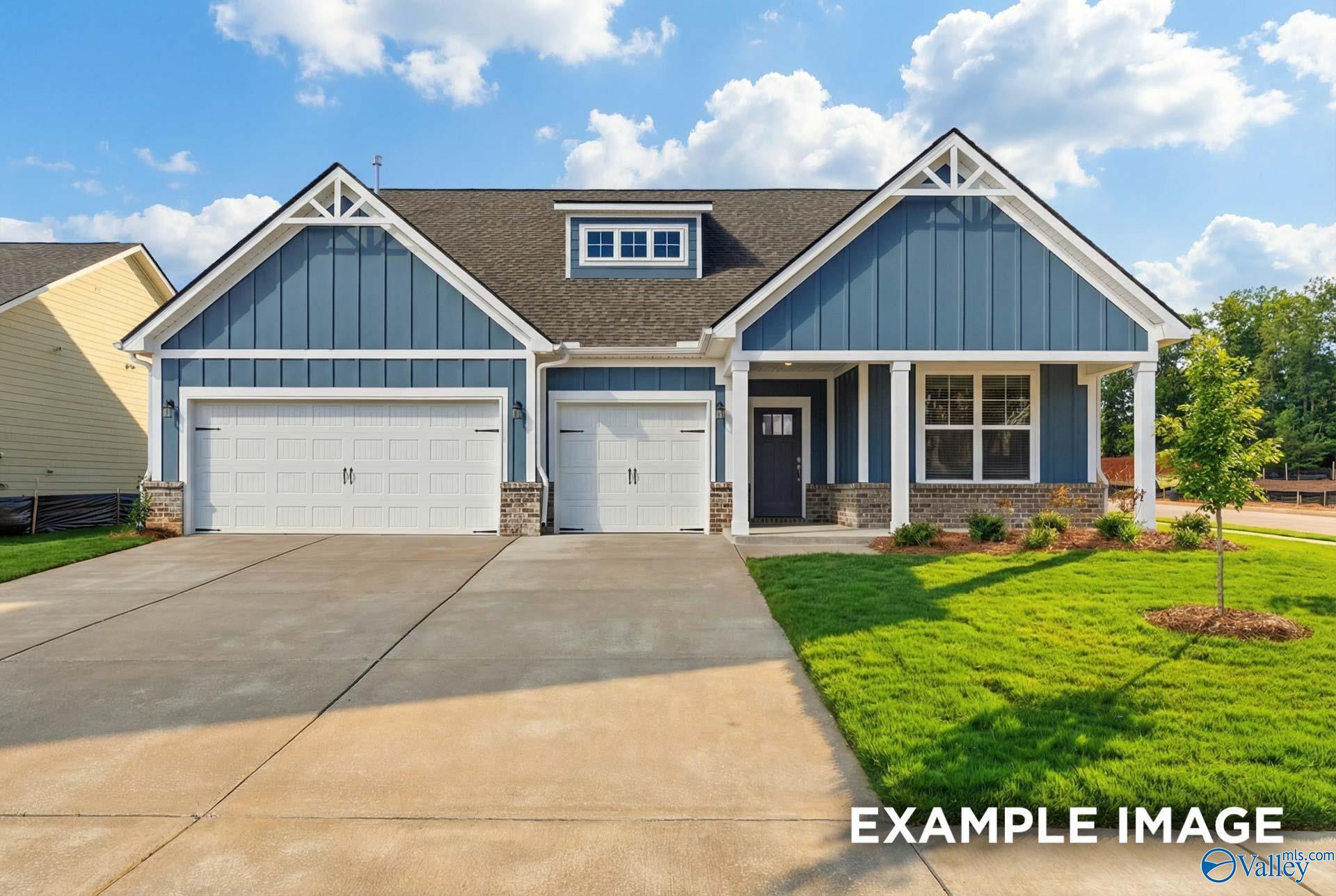 Blue single-story home with gabled roof, dormer window, 2-car garage, and front porch in Evergreen Mill, Madison, Alabama