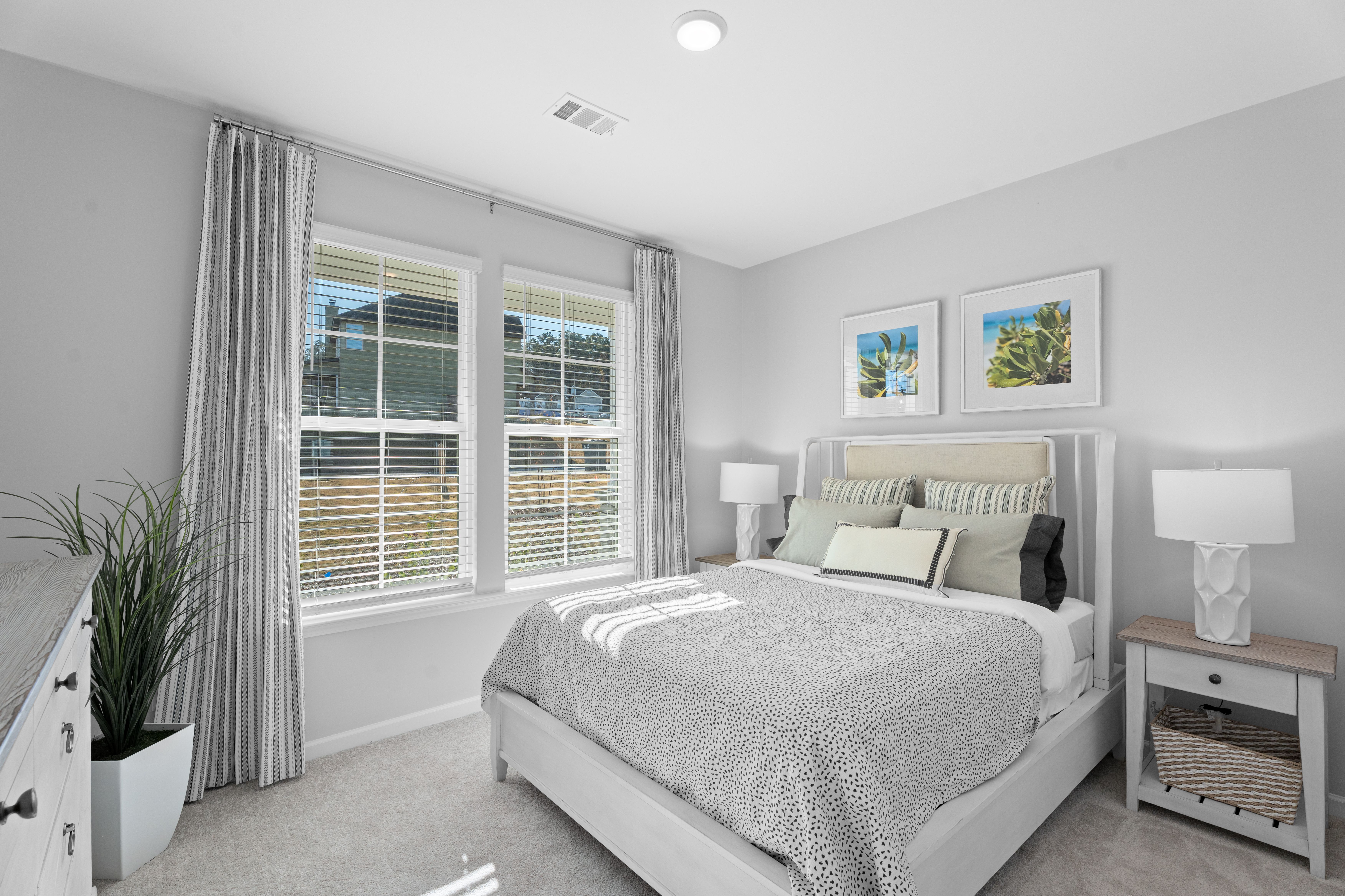 Secondary bedroom shown as a guest bed with queen sized bed and side tables