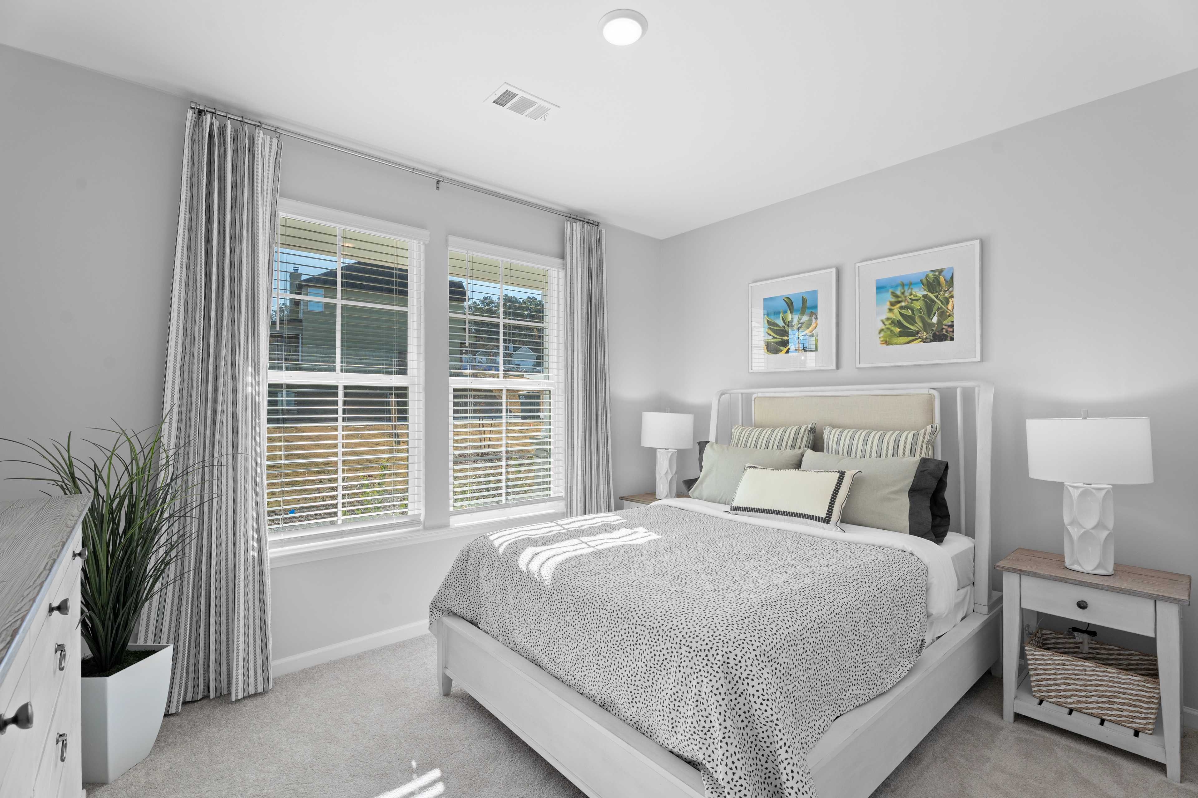 Secondary bedroom shown as a guest bed with queen sized bed and side tables
