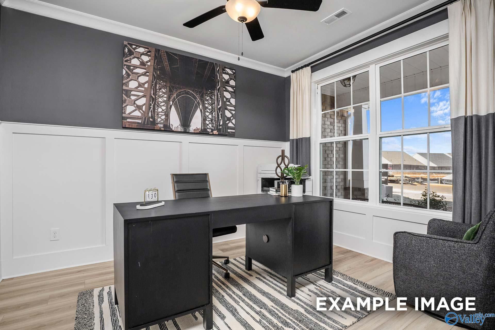 Modern home office with sleek black desk, ceiling fan, Eiffel Tower art, and large window in Davidson Homes The Rockford B, Madison, AL
