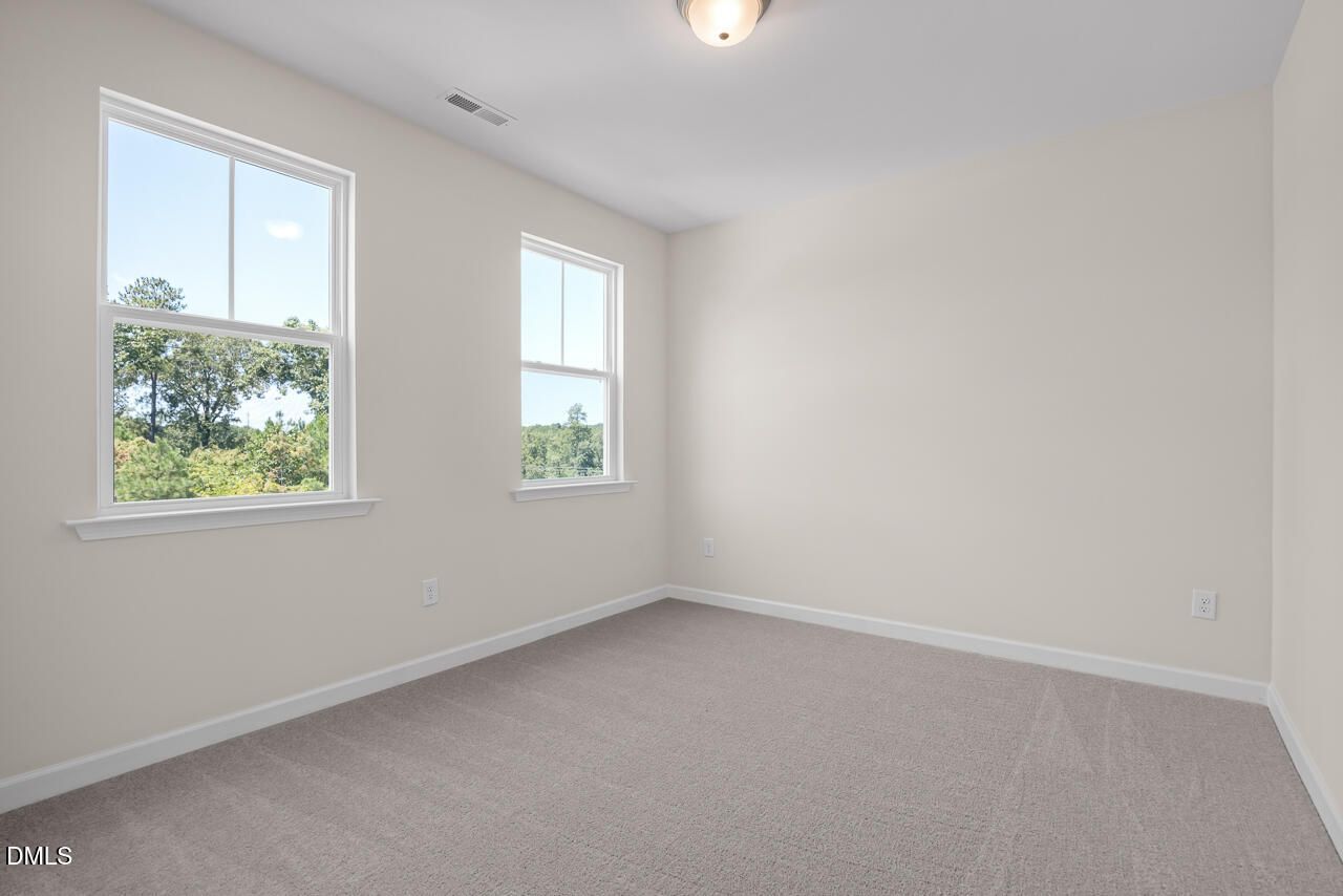 Bright, carpeted bedroom with large windows in The Hickory II B floor plan by Davidson Homes in Montrose, Aberdeen, NC.
