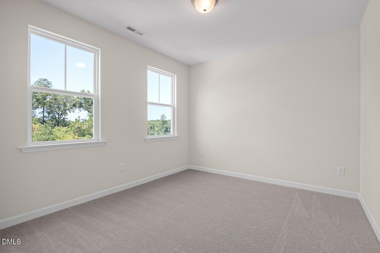 Bright, carpeted bedroom with large windows in The Hickory II B floor plan by Davidson Homes in Montrose, Aberdeen, NC.
