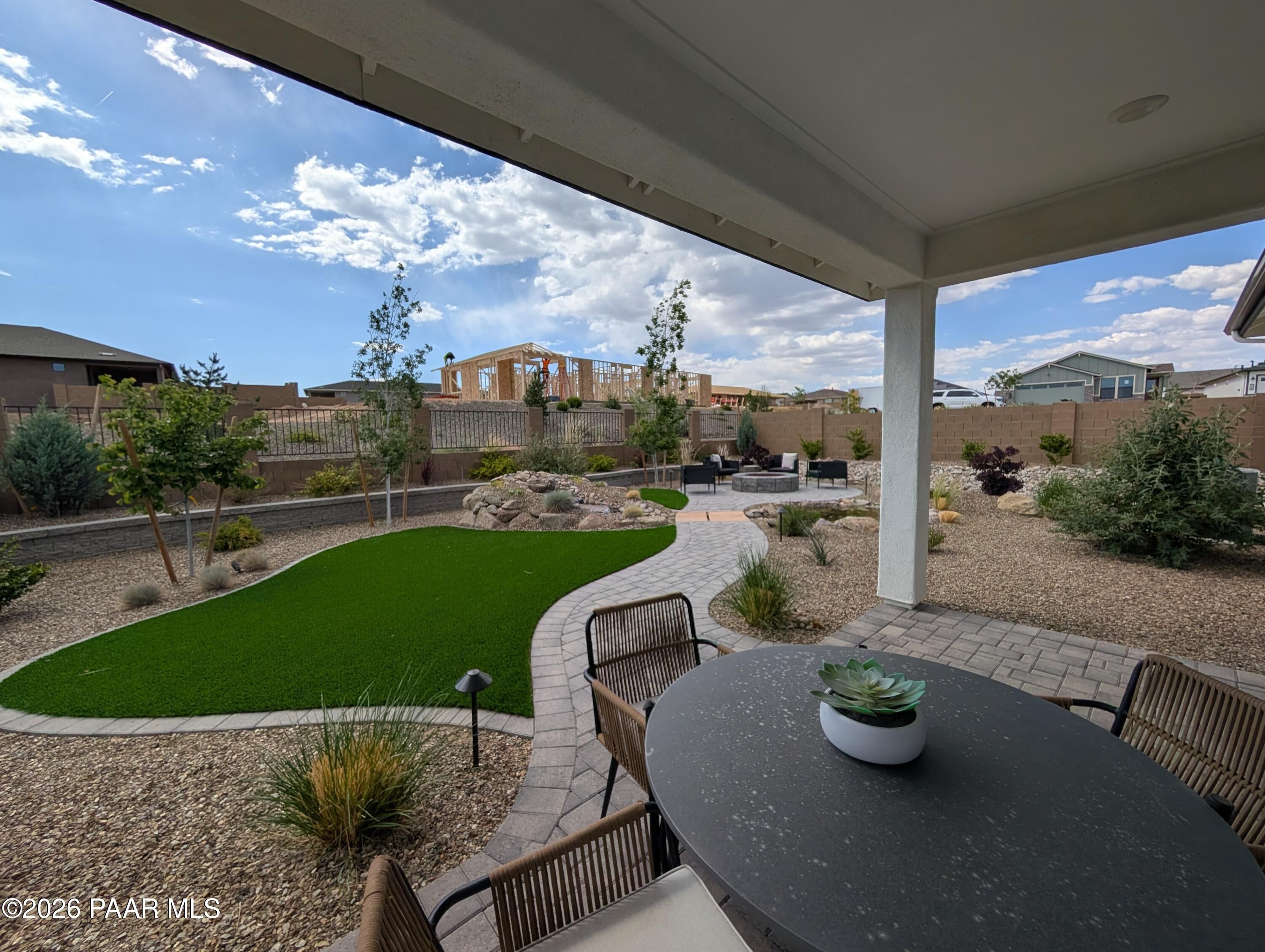 Covered patio with dining area overlooking landscaped backyard in South Ranch Western Collection, Prescott, Arizona.