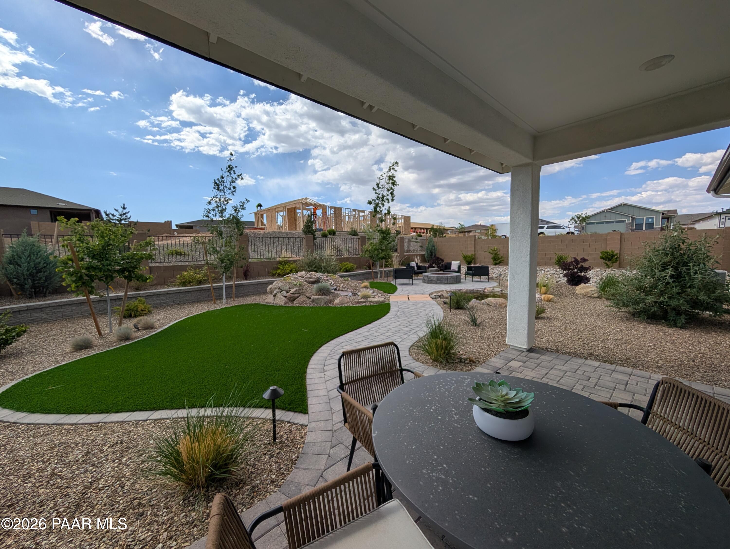 Covered patio with dining area overlooking landscaped backyard in South Ranch Western Collection, Prescott, Arizona.