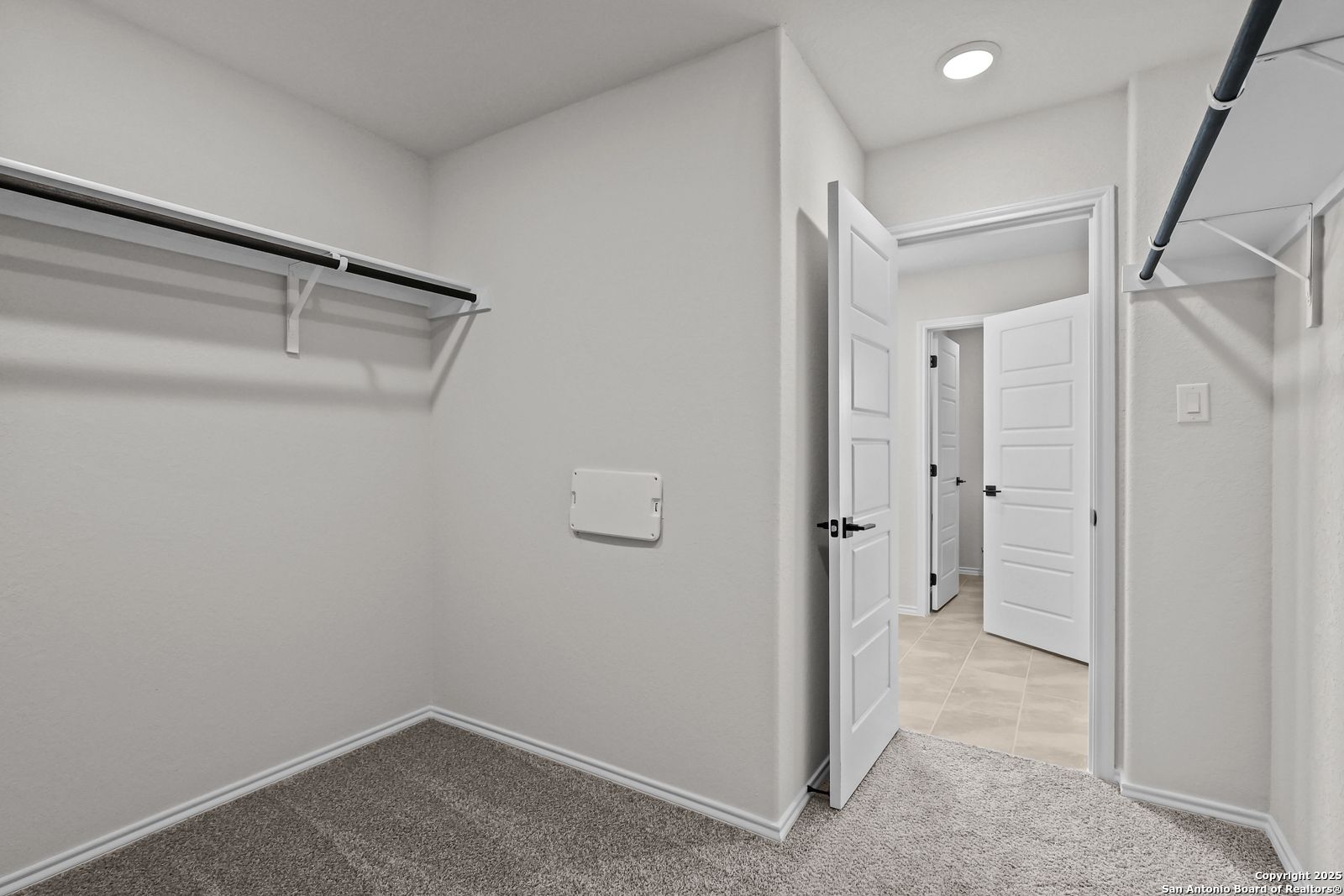 Spacious walk-in closet with built-in shelving and hanging rods in Davidson Homes The Florence C, Cedar Heights, San Antonio