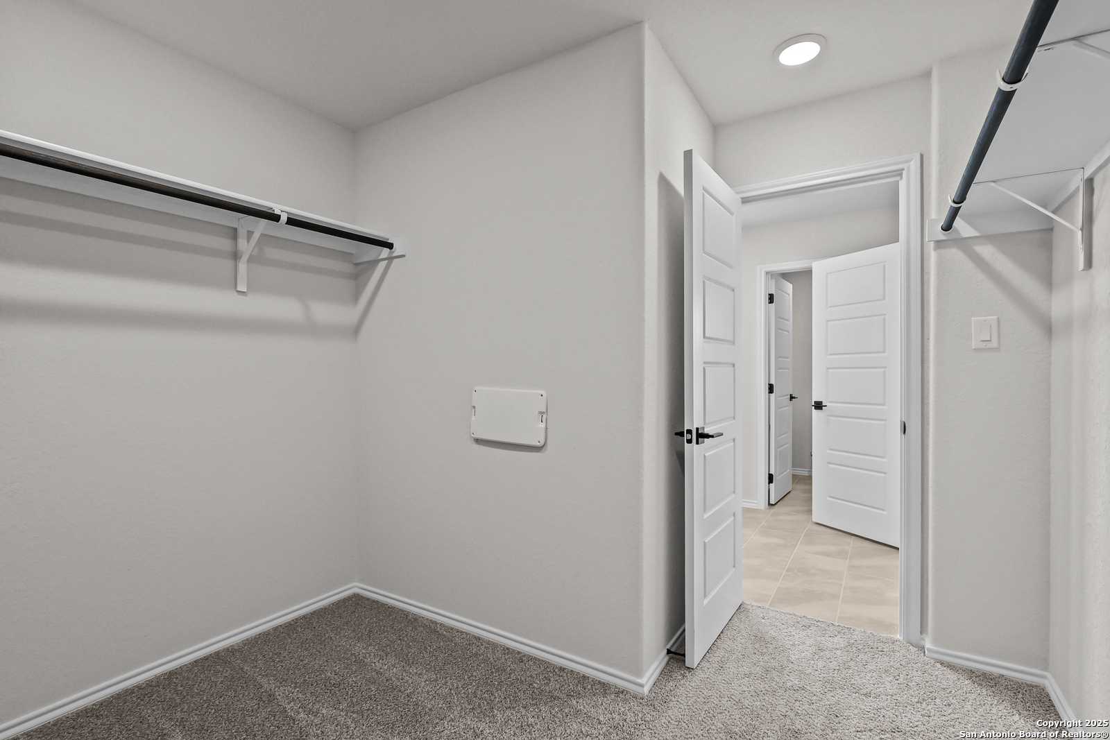 Spacious walk-in closet with built-in shelving and hanging rods in Davidson Homes The Florence C, Cedar Heights, San Antonio