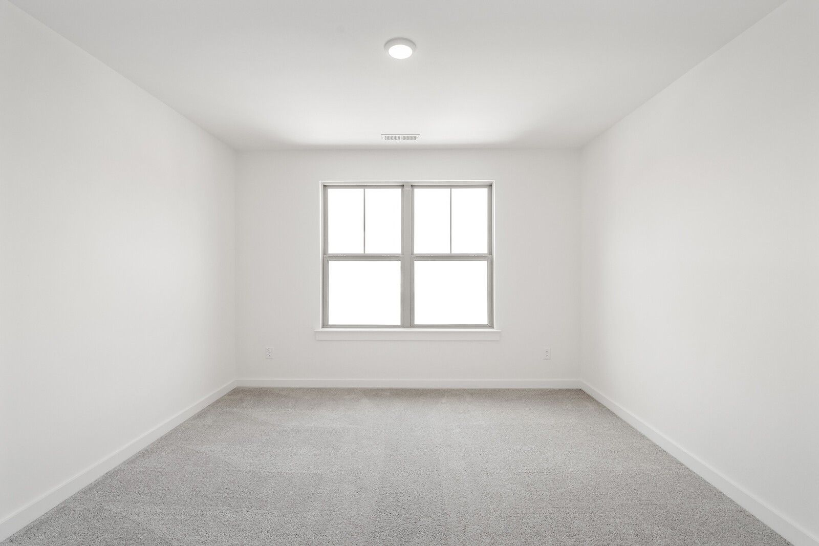 Bright, spacious bedroom with neutral carpet and natural light in The Ridgeport C floor plan at Woods Crossing, Gallatin.