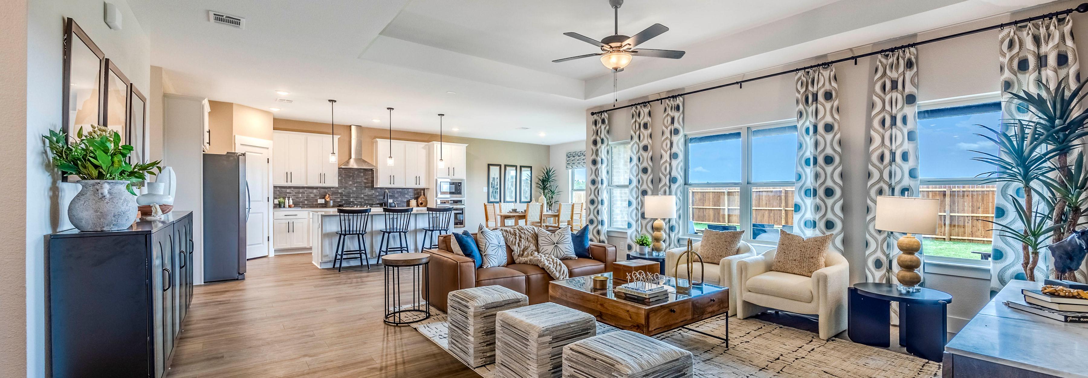 Open-concept living room and kitchen at Waverly Estates in Josephine, Texas with hardwood floors, modern furniture, and large windows