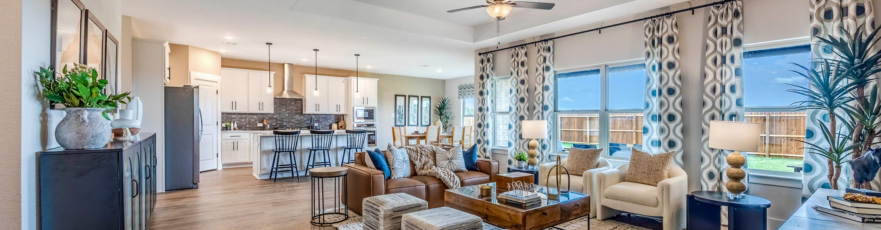 Spacious open-concept living room and kitchen in new Nevada home with modern furniture, hardwood floors, and large windows