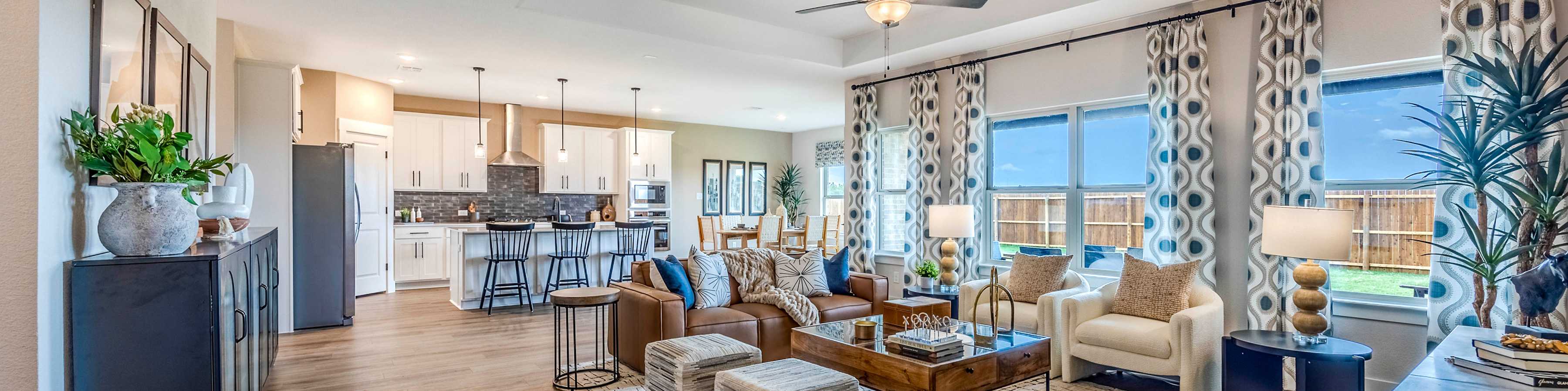 Spacious open-concept living room and kitchen in new Nevada home with modern furniture, hardwood floors, and large windows