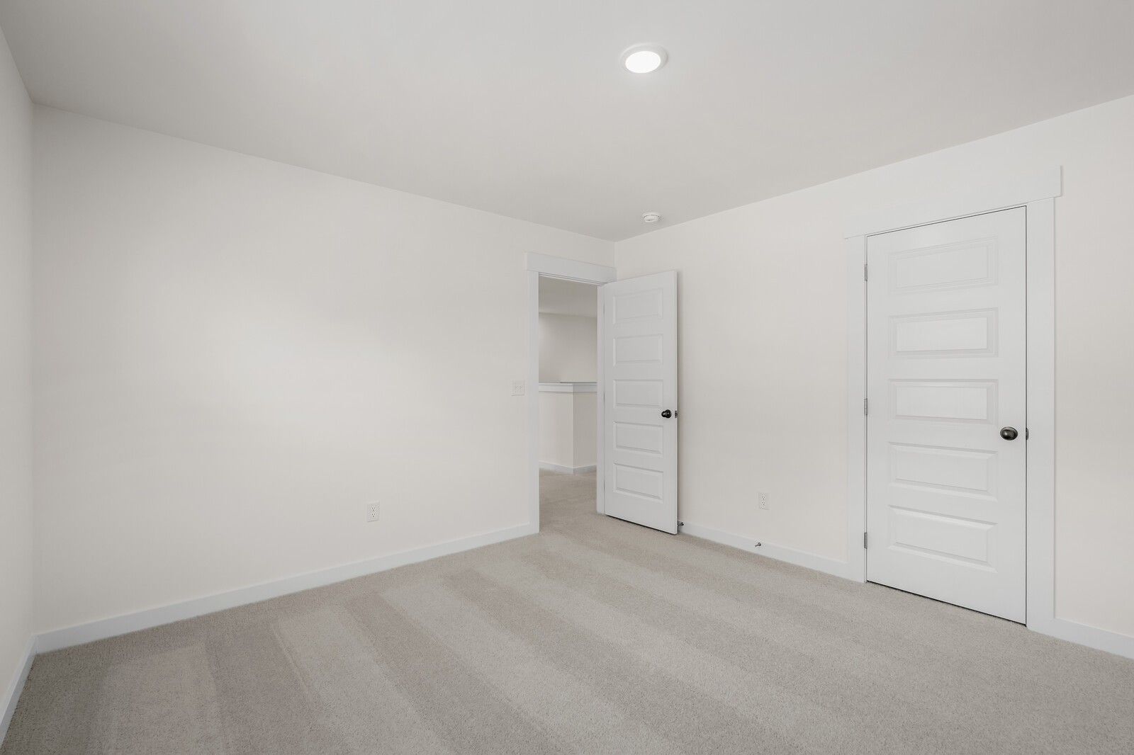 Bright, neutral bedroom with plush carpeting in The Willow floor plan at Woods Crossing in Gallatin, Tennessee.