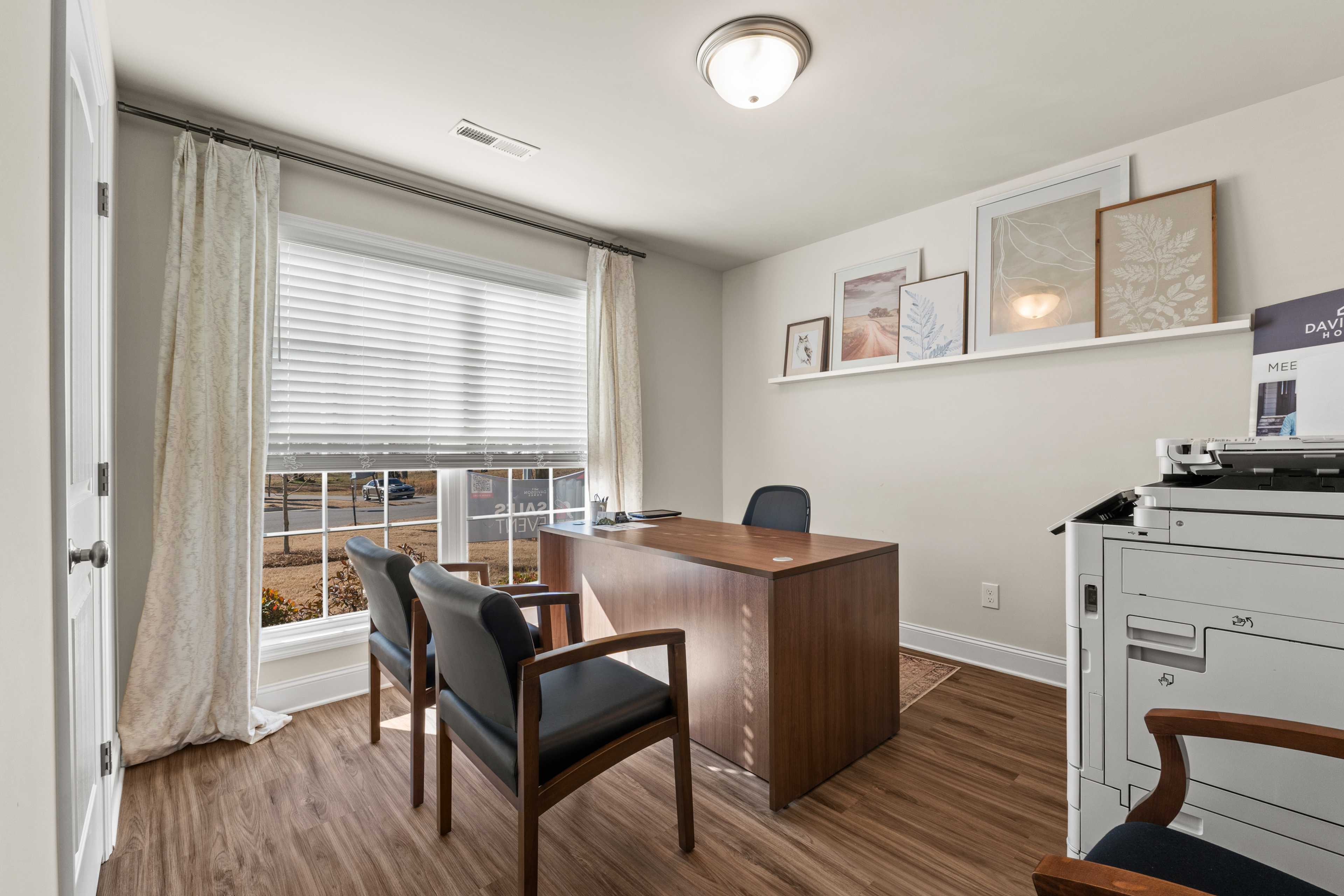 Modern home office at Noble Ridge in Cullman Alabama with wooden desk, large window blinds, and wall shelves