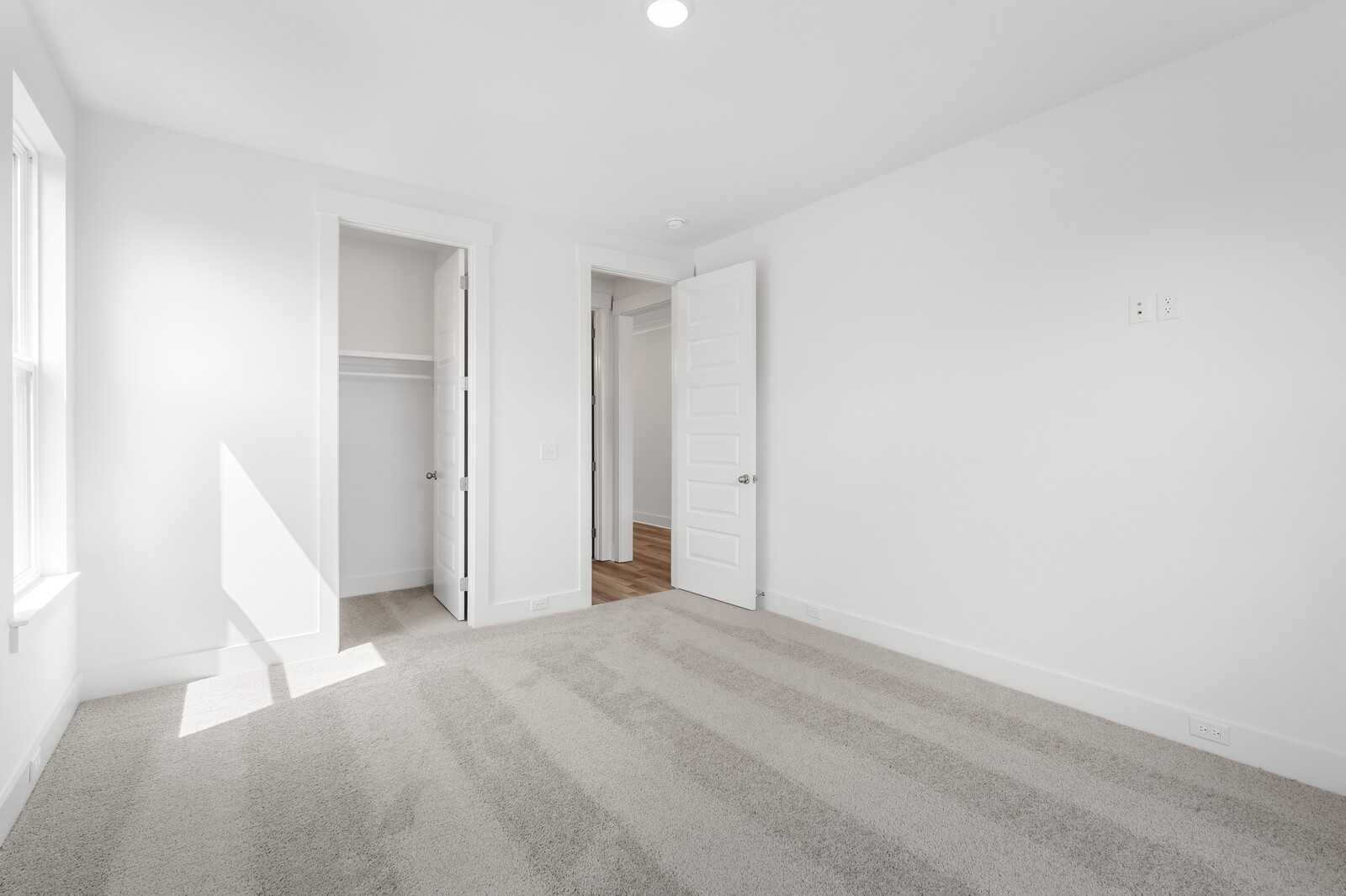 Bright bedroom with walk-in closet and open en-suite bathroom door in Davidson Homes The Hathaway, Murfreesboro, TN