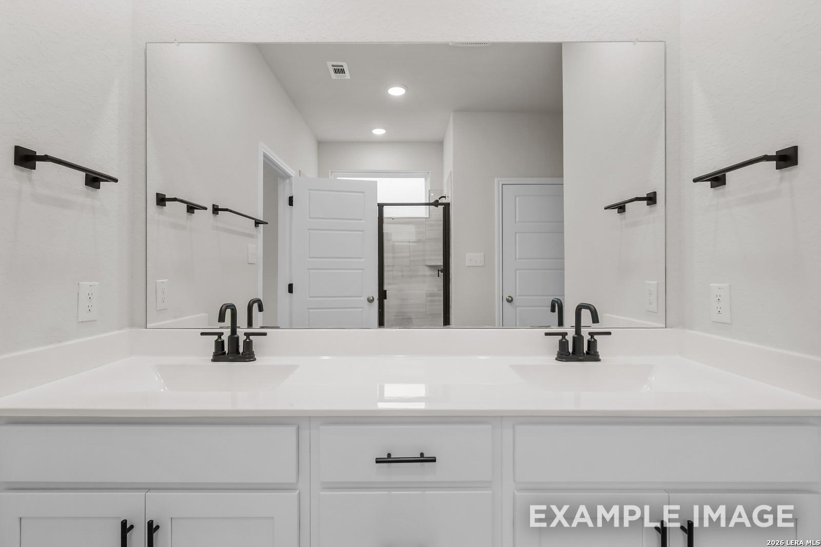 Modern double vanity with matte black fixtures in a Davidson Homes Sequoia C floor plan bathroom, Royal Crest, San Antonio.