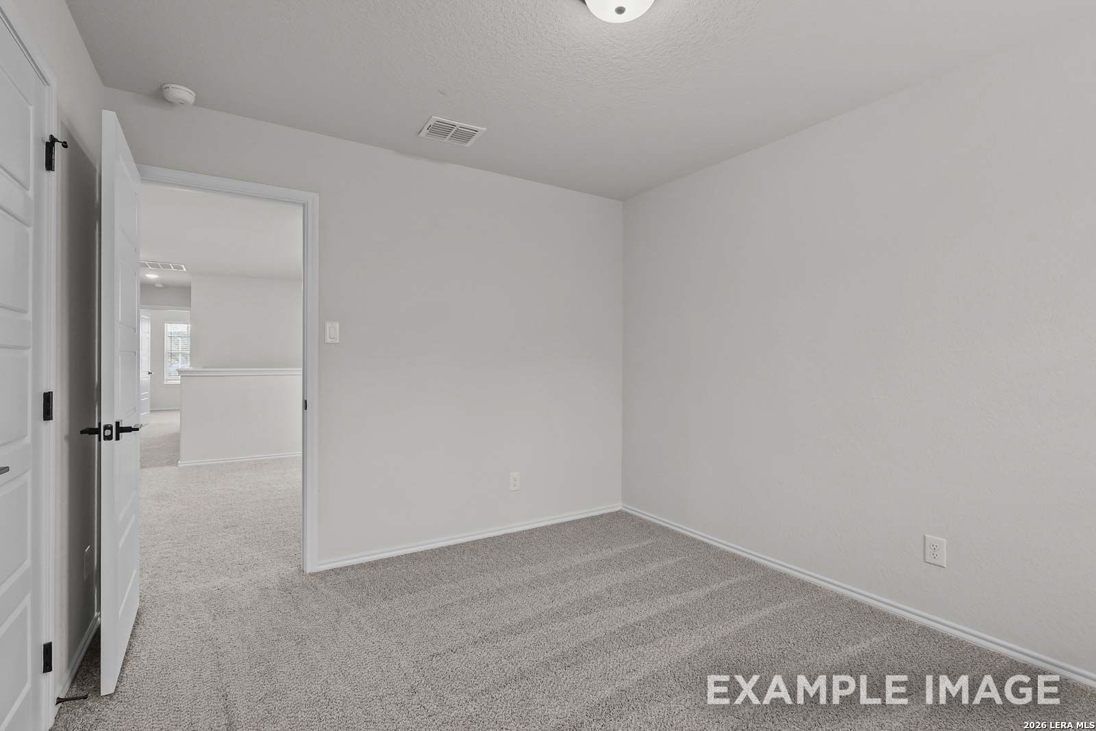 Spacious carpeted secondary bedroom in The Florence D floor plan by Davidson Homes in Cedar Heights, San Antonio, Texas.