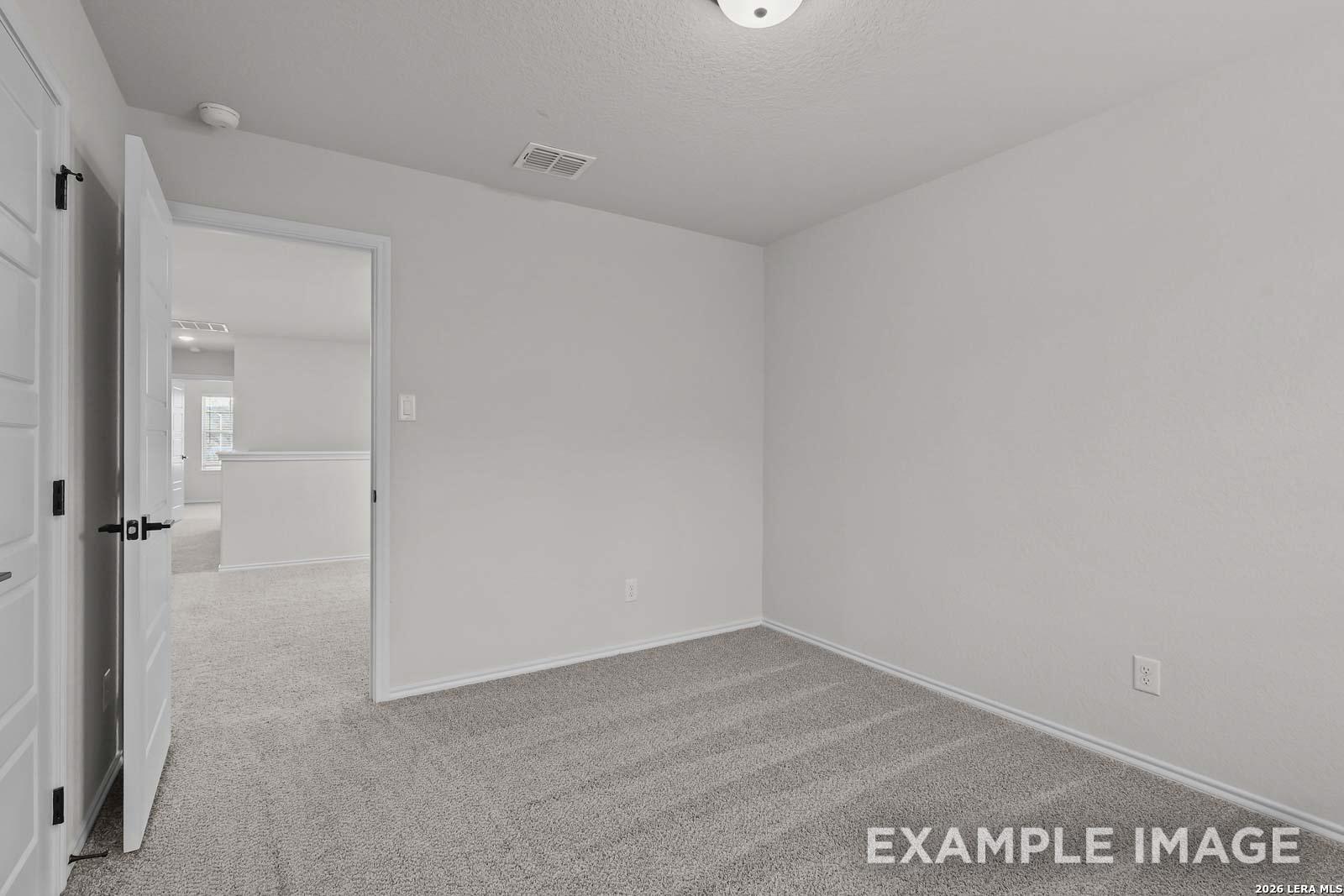 Spacious carpeted secondary bedroom in The Florence D floor plan by Davidson Homes in Cedar Heights, San Antonio, Texas.