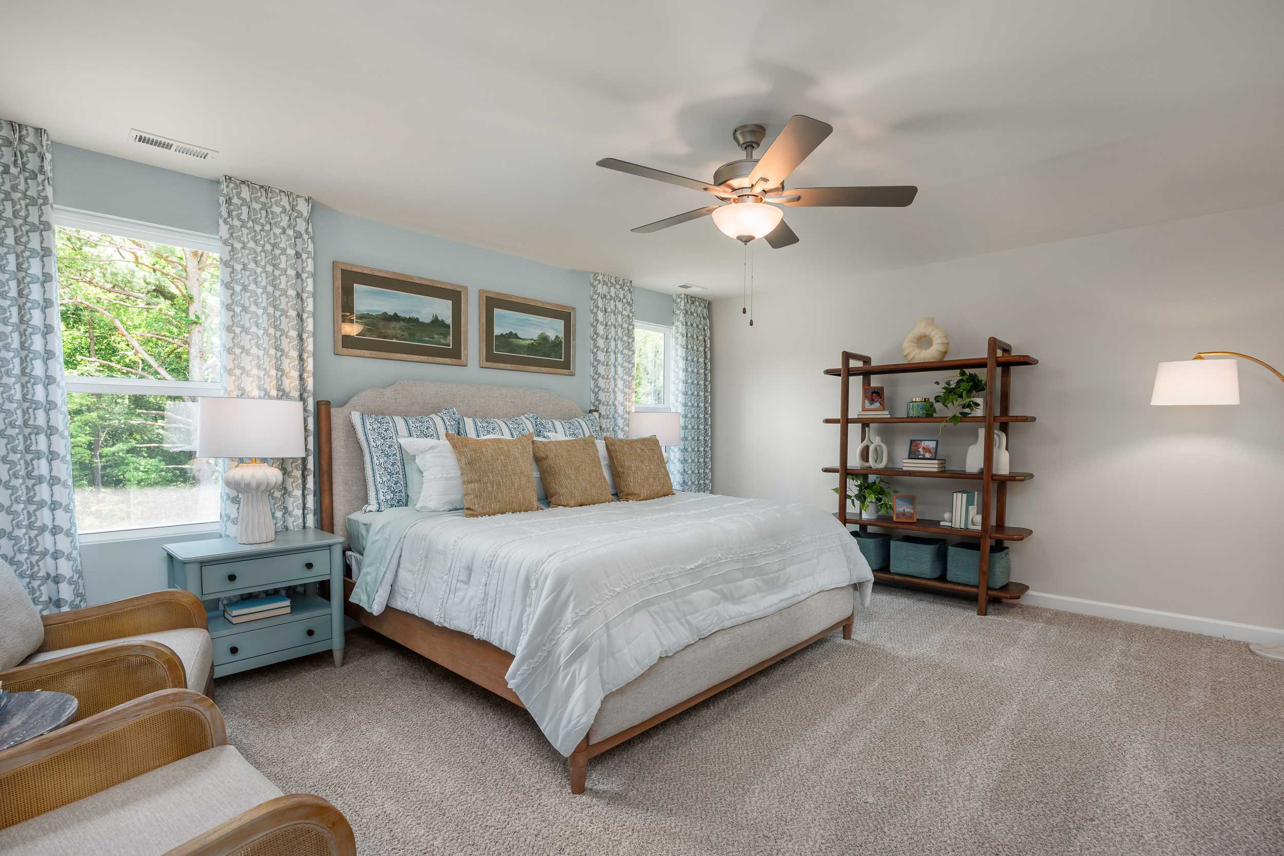 Spacious primary bedroom at Retreat at North Main in Lillington NC with king bed, ceiling fan, and modern furnishings by Davidson Homes