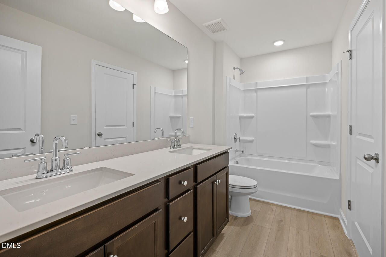 Modern bathroom with dual-sink vanity and tub-shower combo in The Gavin A floor plan, Gregory Village, Lillington, NC.