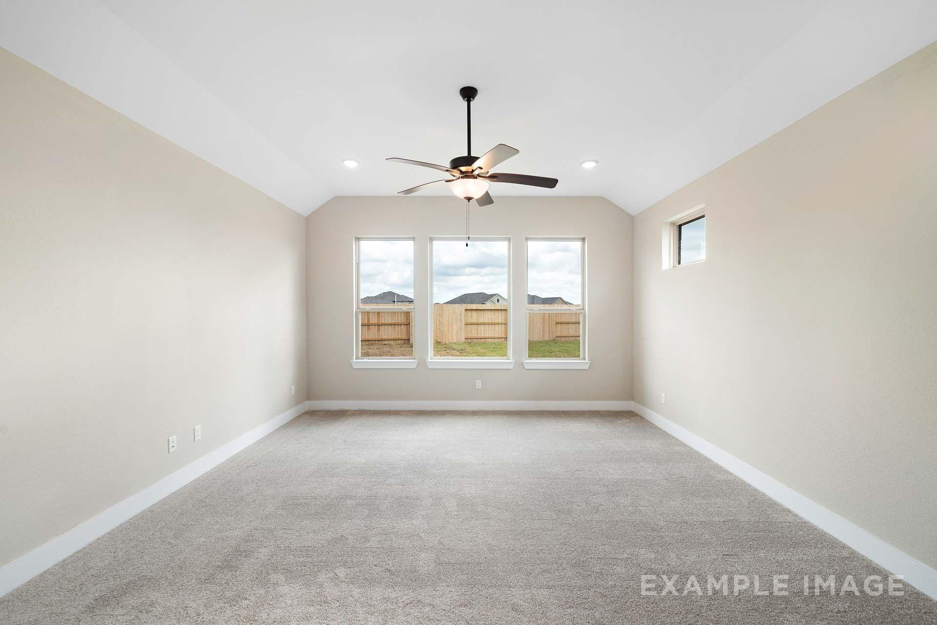 Spacious master suite in The Elizabeth by Davidson Homes, featuring vaulted ceiling, ceiling fan, and backyard-facing windows.