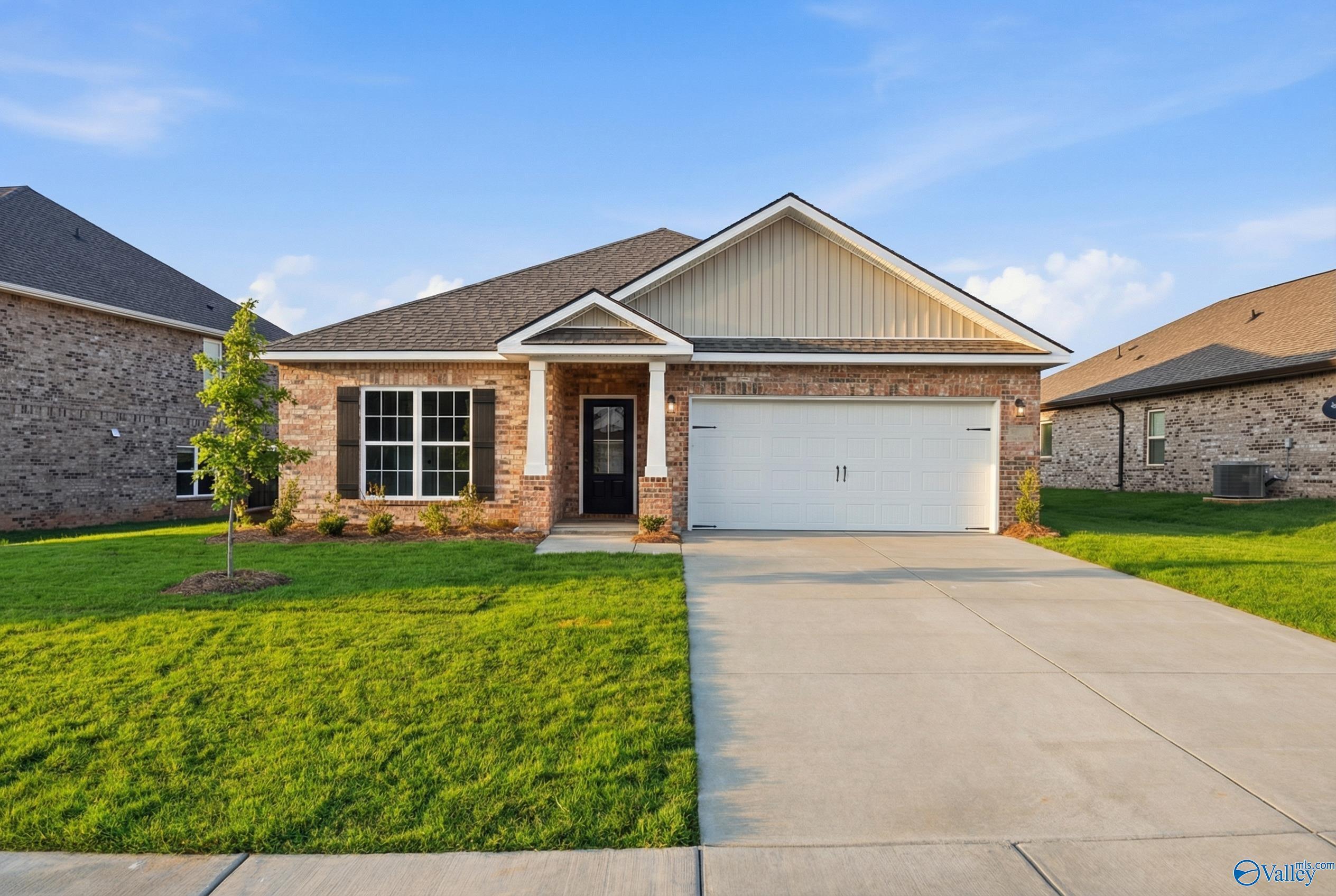 Modern brick single-story home with gable roof, 2-car garage, and lush green lawn in Creekside, Harvest, Alabama - Davidson Homes The Daphne C