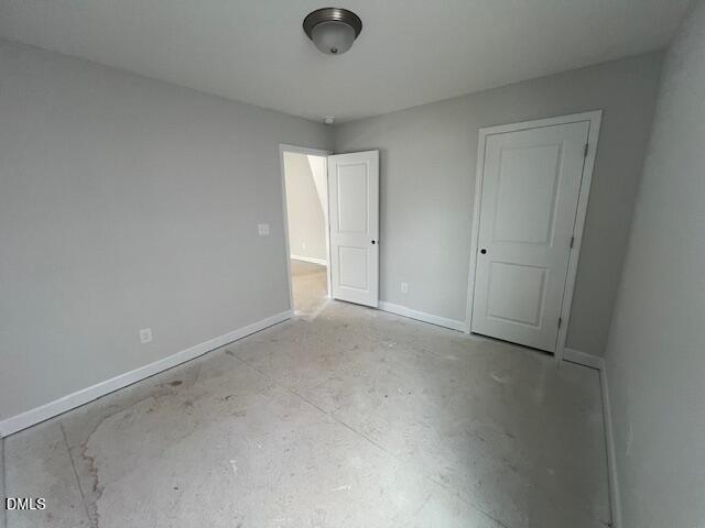 Empty secondary bedroom with gray walls, white doors, ceiling light, and plywood subfloor in Davidson Homes The Adalynn B, Lillington NC