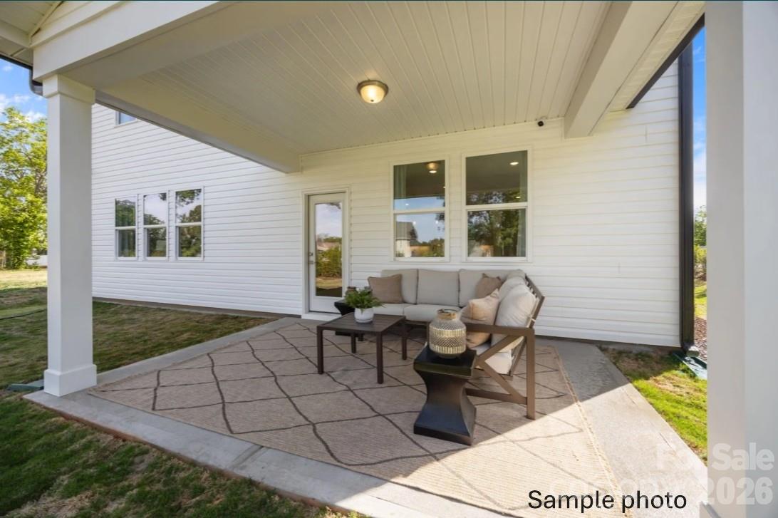 Covered back patio with outdoor seating at The Beech B floor plan in Enclave at Belmont, Belmont, North Carolina.