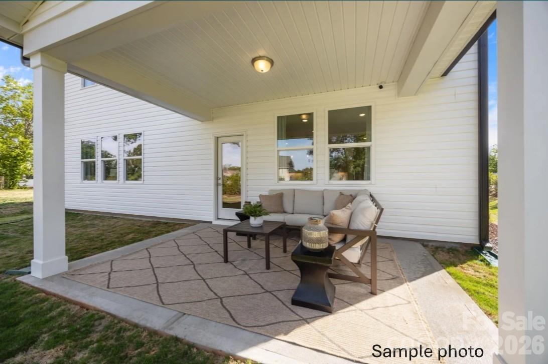 Covered back patio with outdoor seating at The Beech B floor plan in Enclave at Belmont, Belmont, North Carolina.