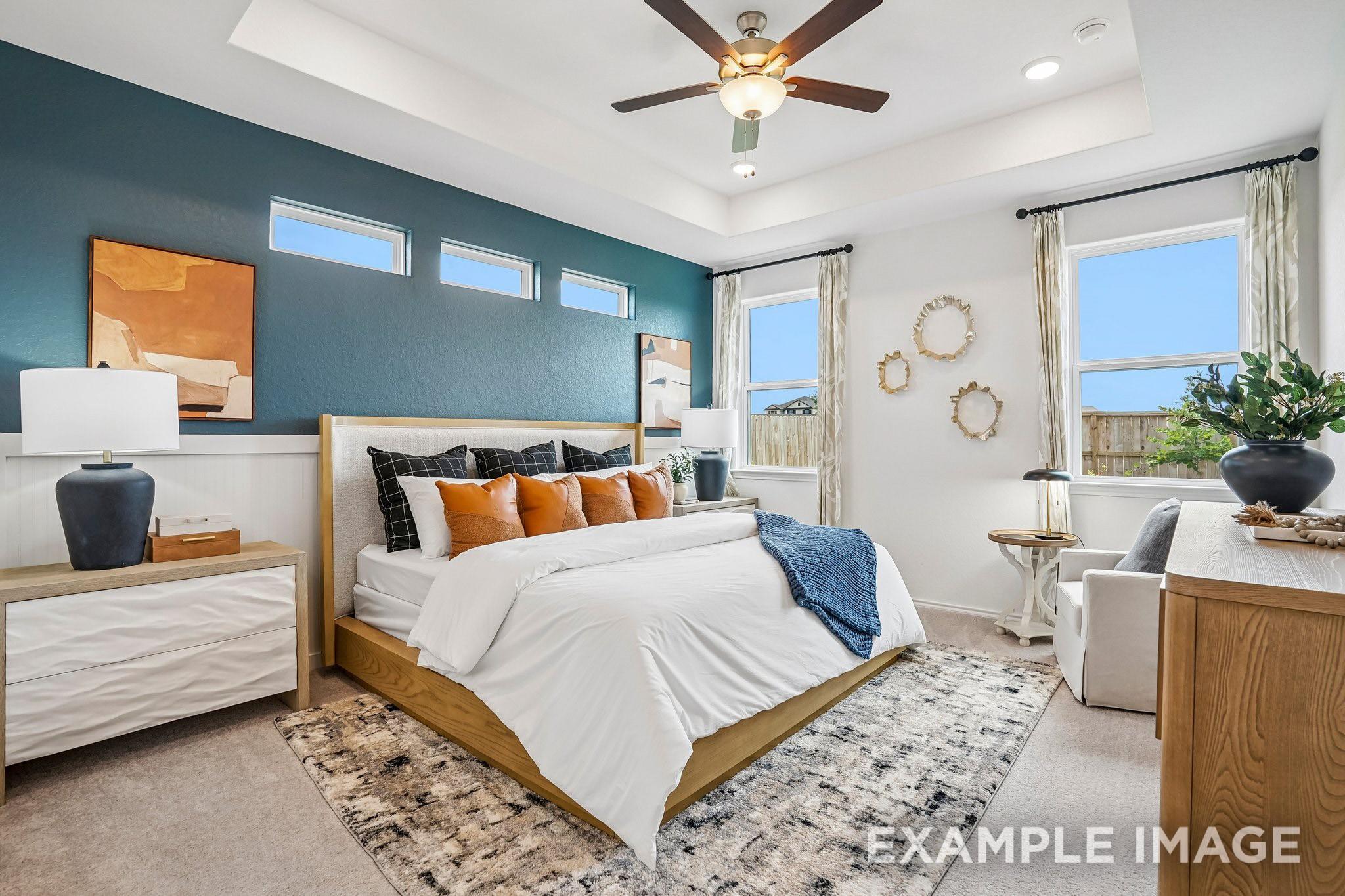 Primary bedroom with tray ceiling, accent wall, and ceiling fan in The Ashport J by Davidson Homes, Sundance Cove, Crosby, TX