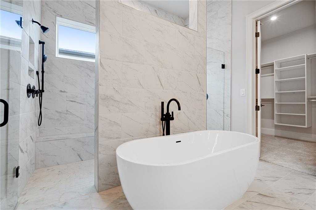 Luxurious master bathroom with freestanding tub, marble shower and black fixtures in Davidson Homes The Seaside B, Woodstock, GA