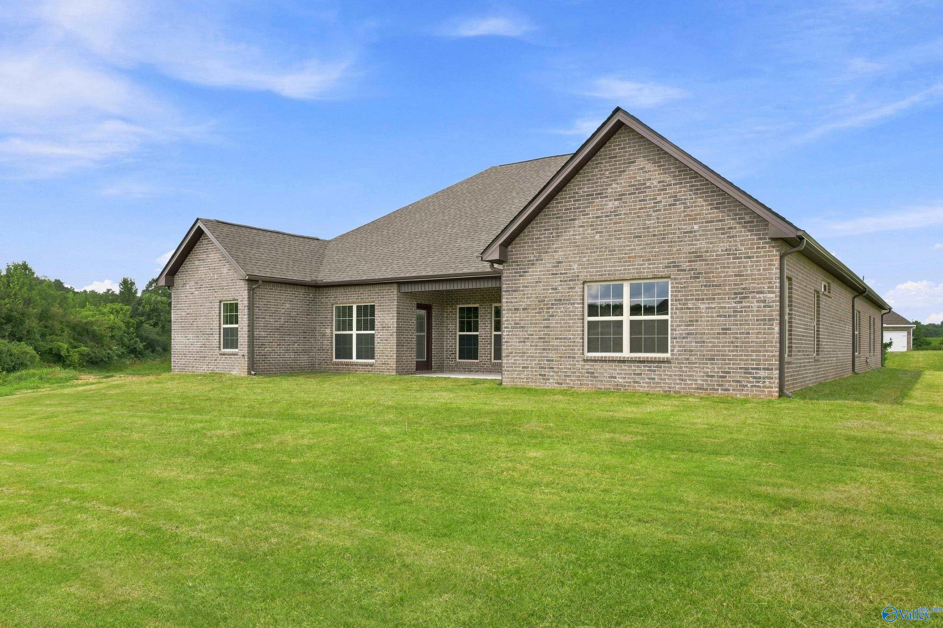 Rear exterior of brick 1-story Davidson Homes Valencia plan with large backyard in Riverton Preserve, Huntsville, Alabama