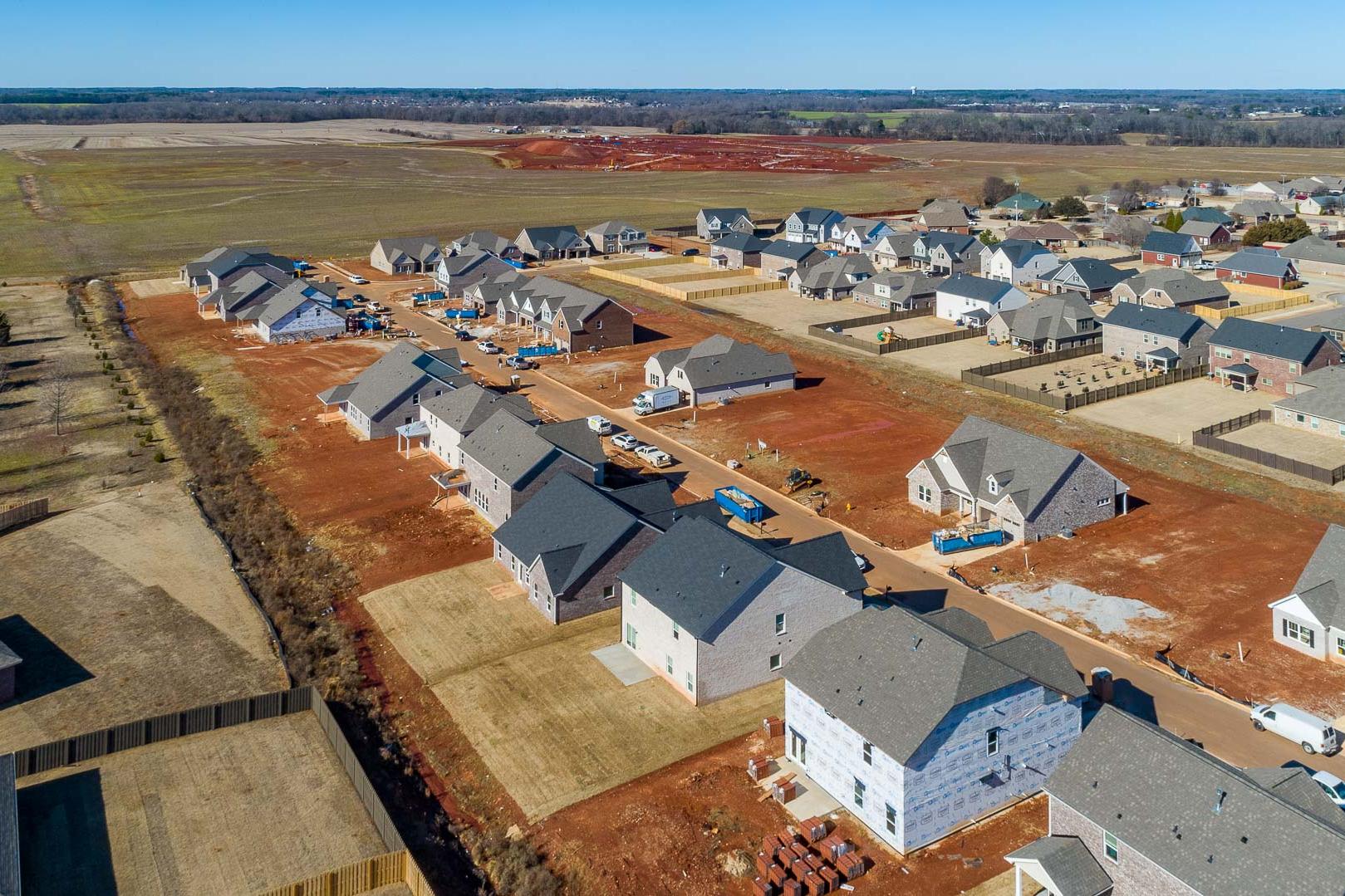 Aerial view of new homes under construction in Old Stone, Athens Alabama with red clay lots and open fields