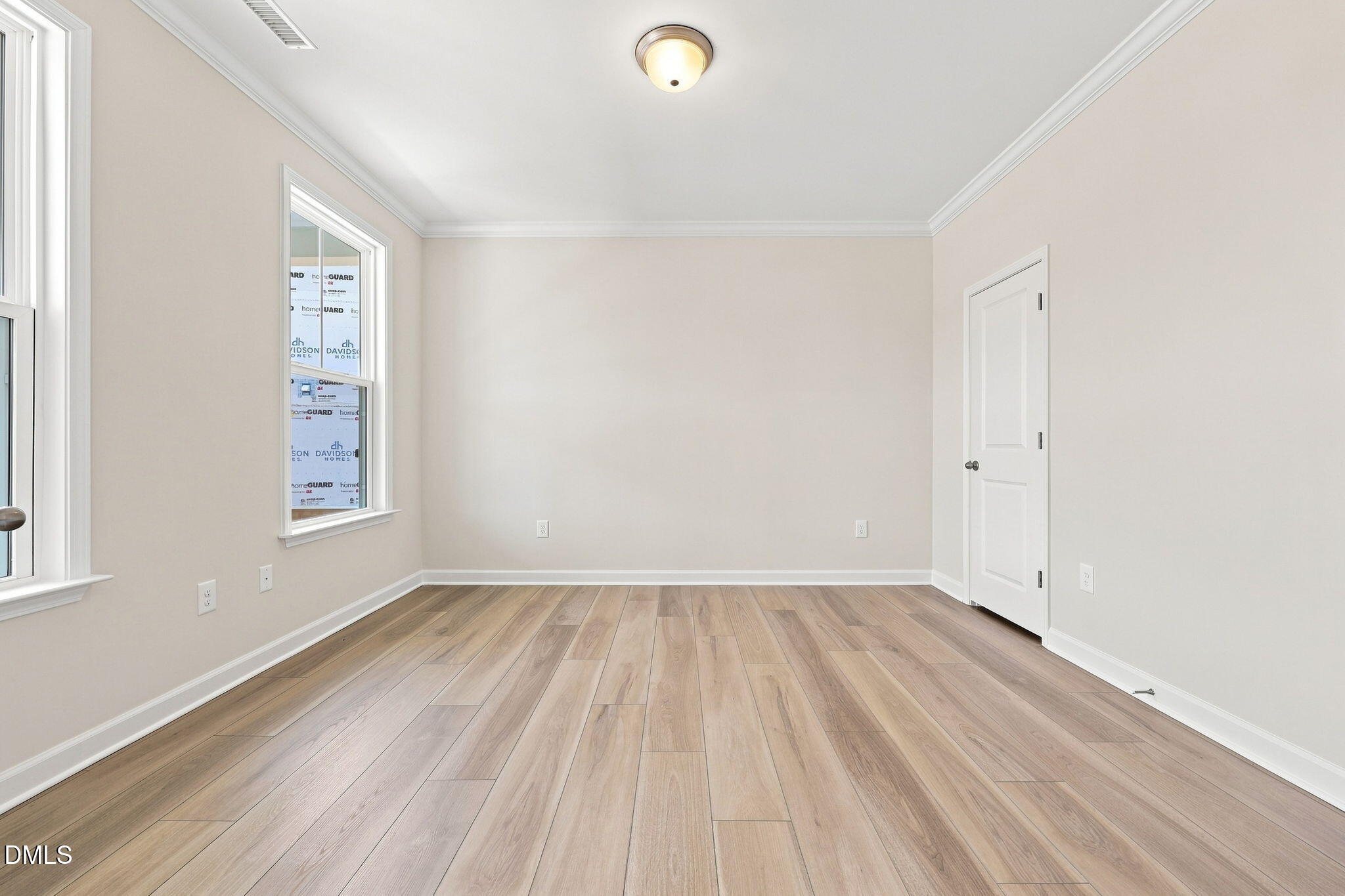 Spacious, light-filled bedroom with wood-style flooring in The Magnolia B floor plan at Retreat at North Main, Lillington.
