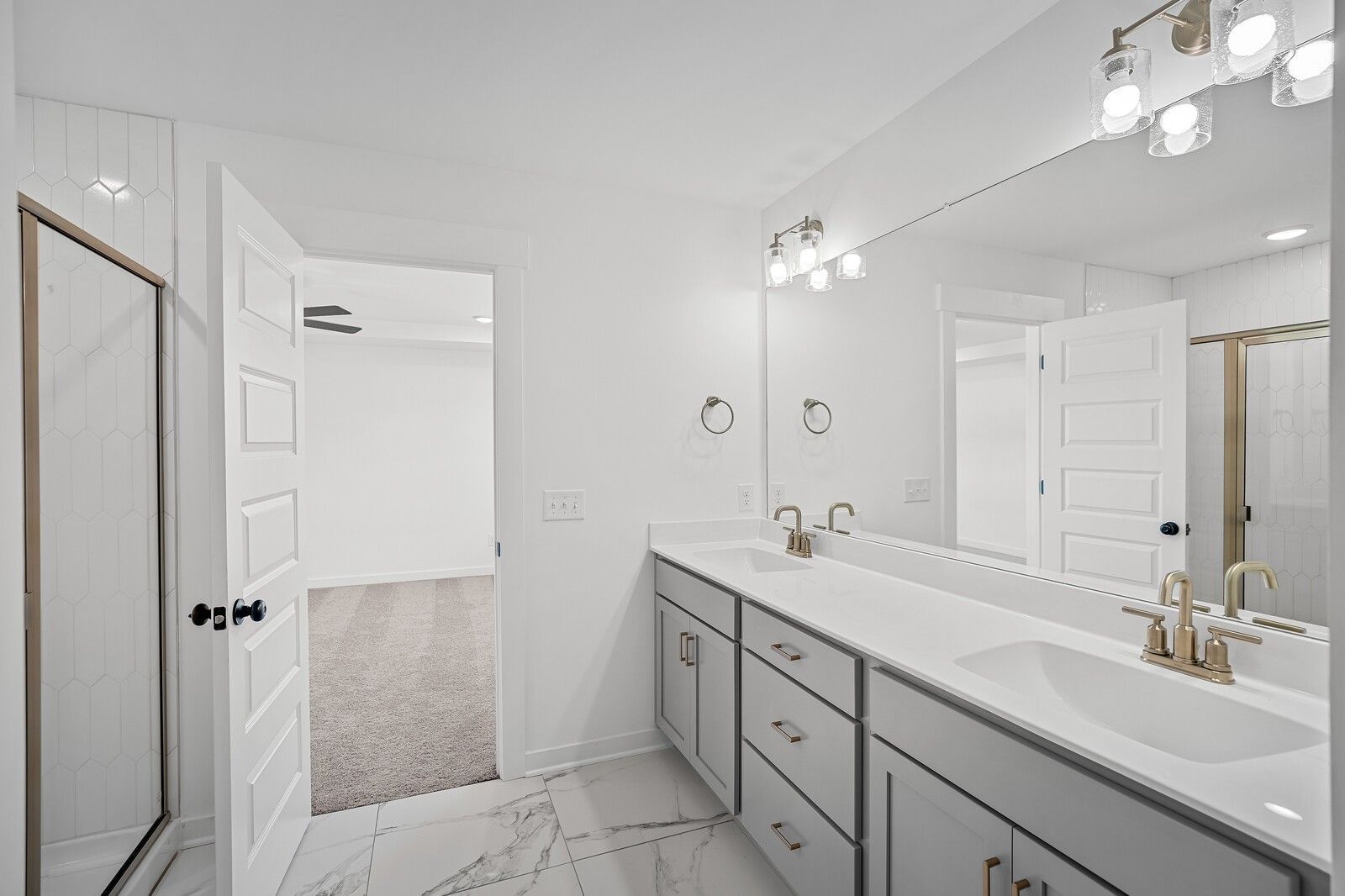 Elegant master bathroom with double vanity, gold faucets, large mirror in Davidson Homes The Logan C, Gallatin, Tennessee