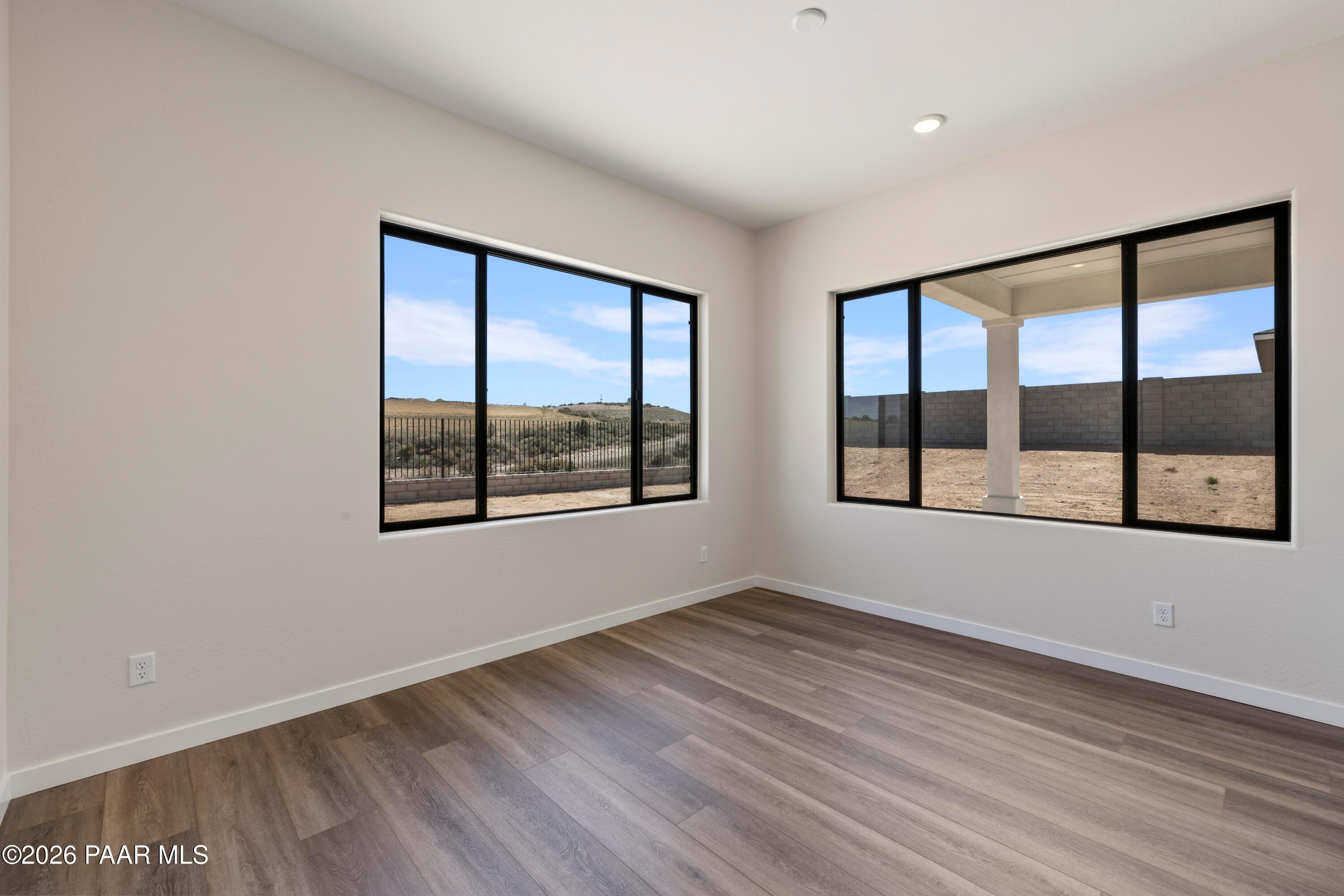 Bright bedroom with large windows showcasing desert hills and covered patio in Davidson Homes The Soleil E, Prescott, Arizona