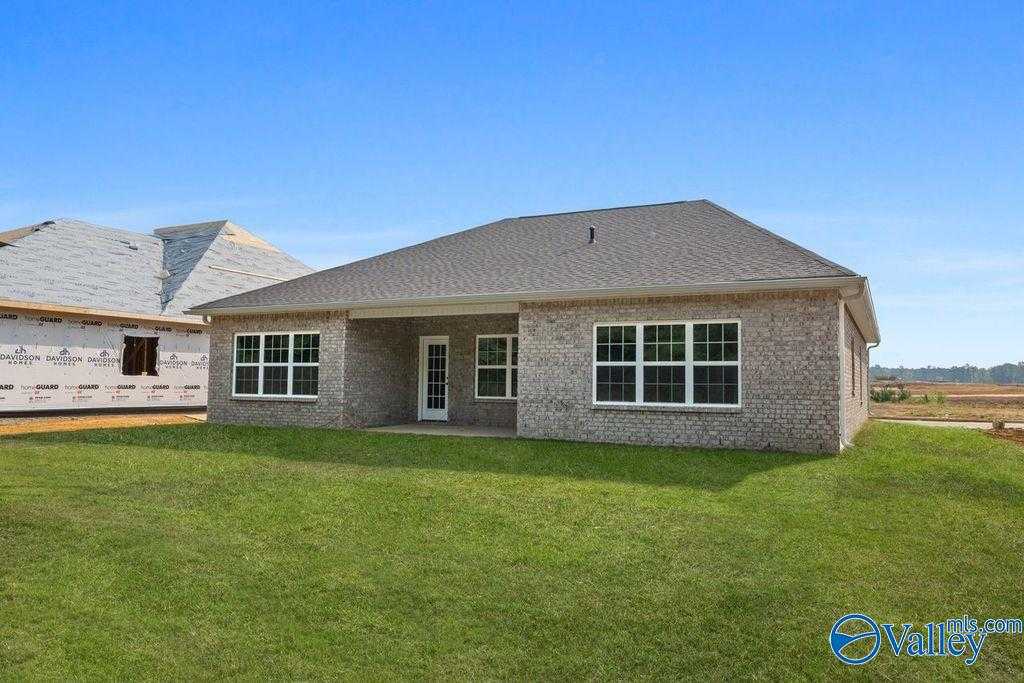 Front view of The Montgomery B single-story brick home by Davidson Homes in Cain Park, Hartselle, Alabama, with gabled roof and lush green lawn