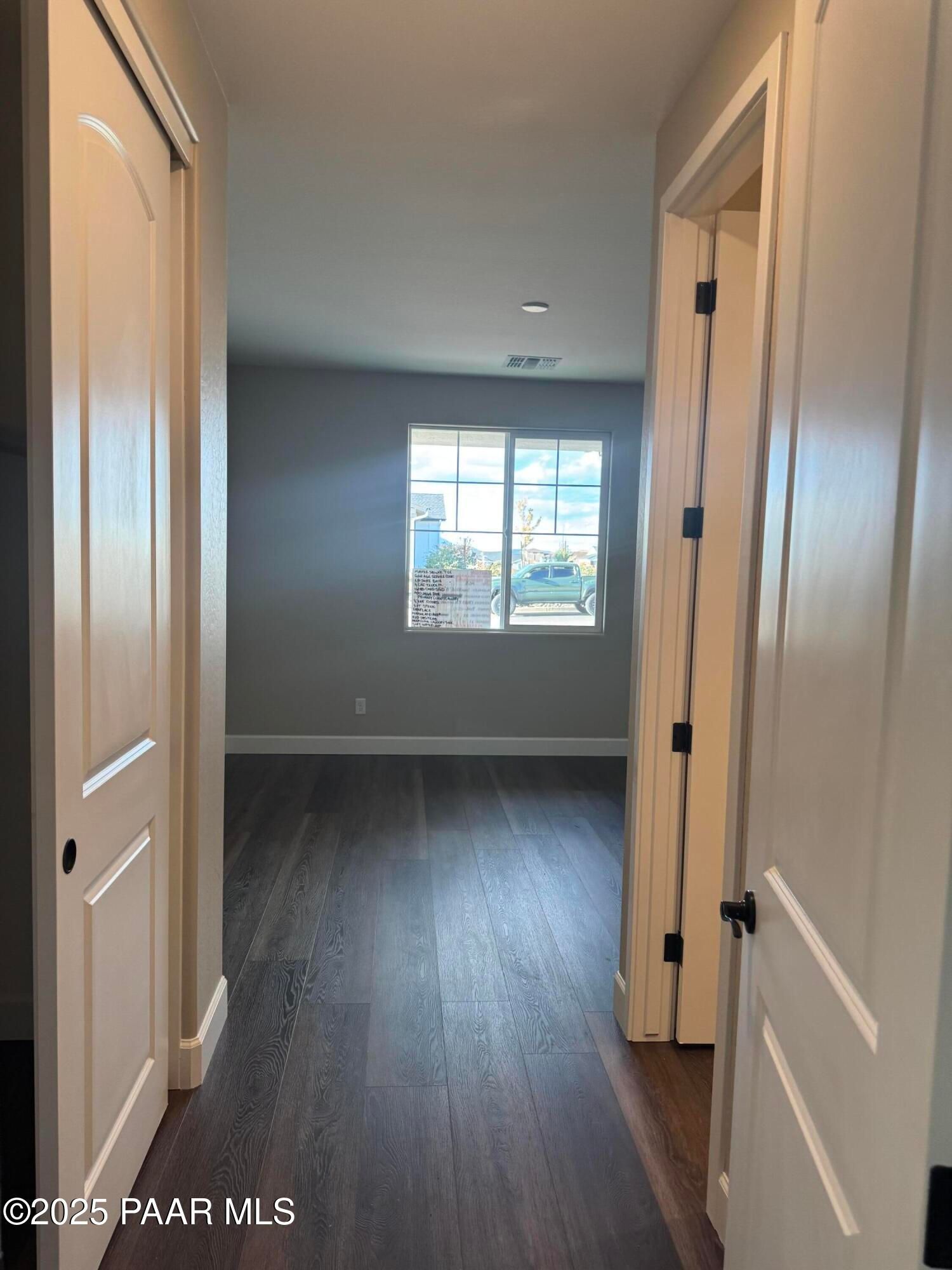 Spacious hallway with luxury vinyl plank flooring, arched doorways, and large window in 3-bedroom Evermore Homes The Sunrise A, Prescott Valley, Arizona