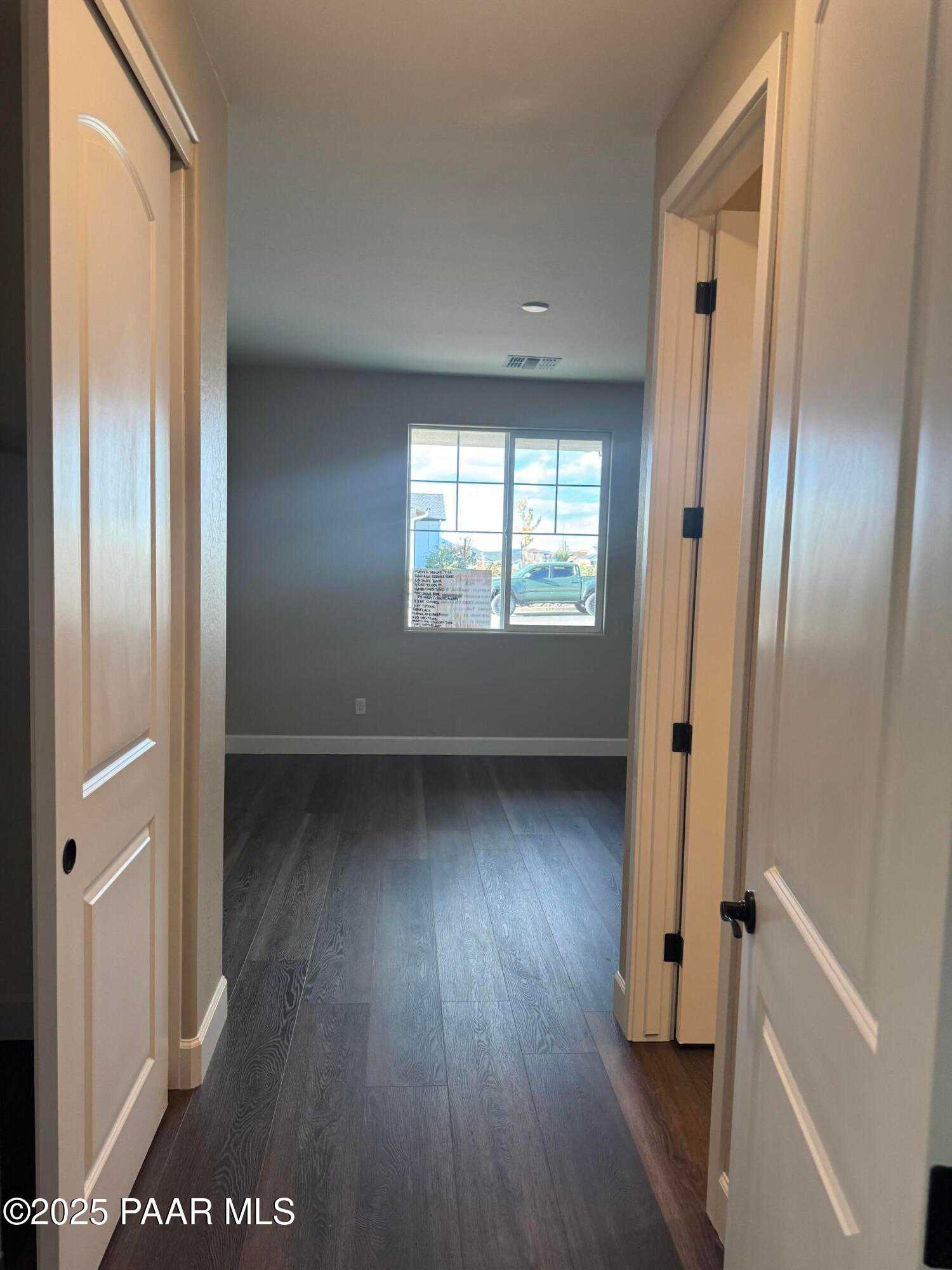 Spacious hallway with luxury vinyl plank flooring, arched doorways, and large window in 3-bedroom Evermore Homes The Sunrise A, Prescott Valley, Arizona