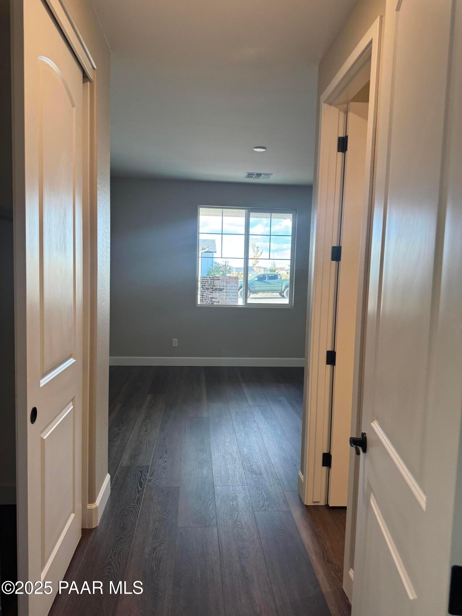 Spacious hallway with luxury vinyl plank flooring, arched doorways, and large window in 3-bedroom Evermore Homes The Sunrise A, Prescott Valley, Arizona