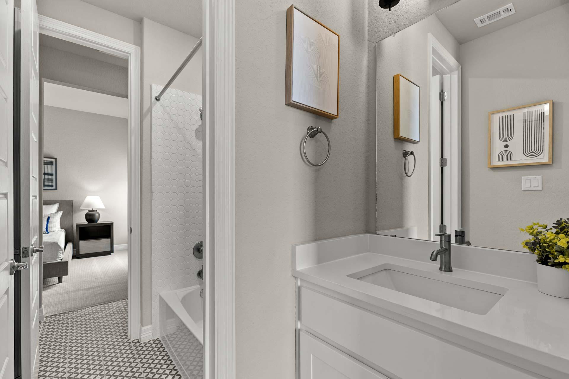 Spacious primary bathroom at Potranco Oaks in Castroville TX featuring walk-in shower, soaking tub, and modern vanity with adjacent bedroom view