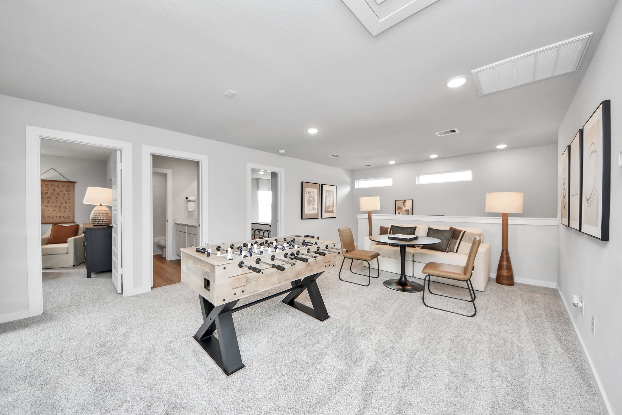 Spacious game room with foosball table and lounge area at Robins Landing in Houston, TX by Davidson Homes.