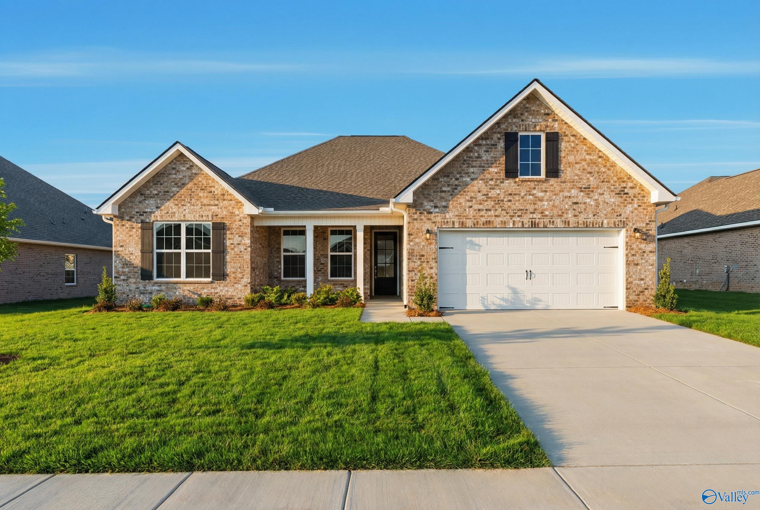 Brick single-story home with gabled roof, 2-car garage, front porch and manicured lawn in Pikes Ridge, Meridianville, Alabama
