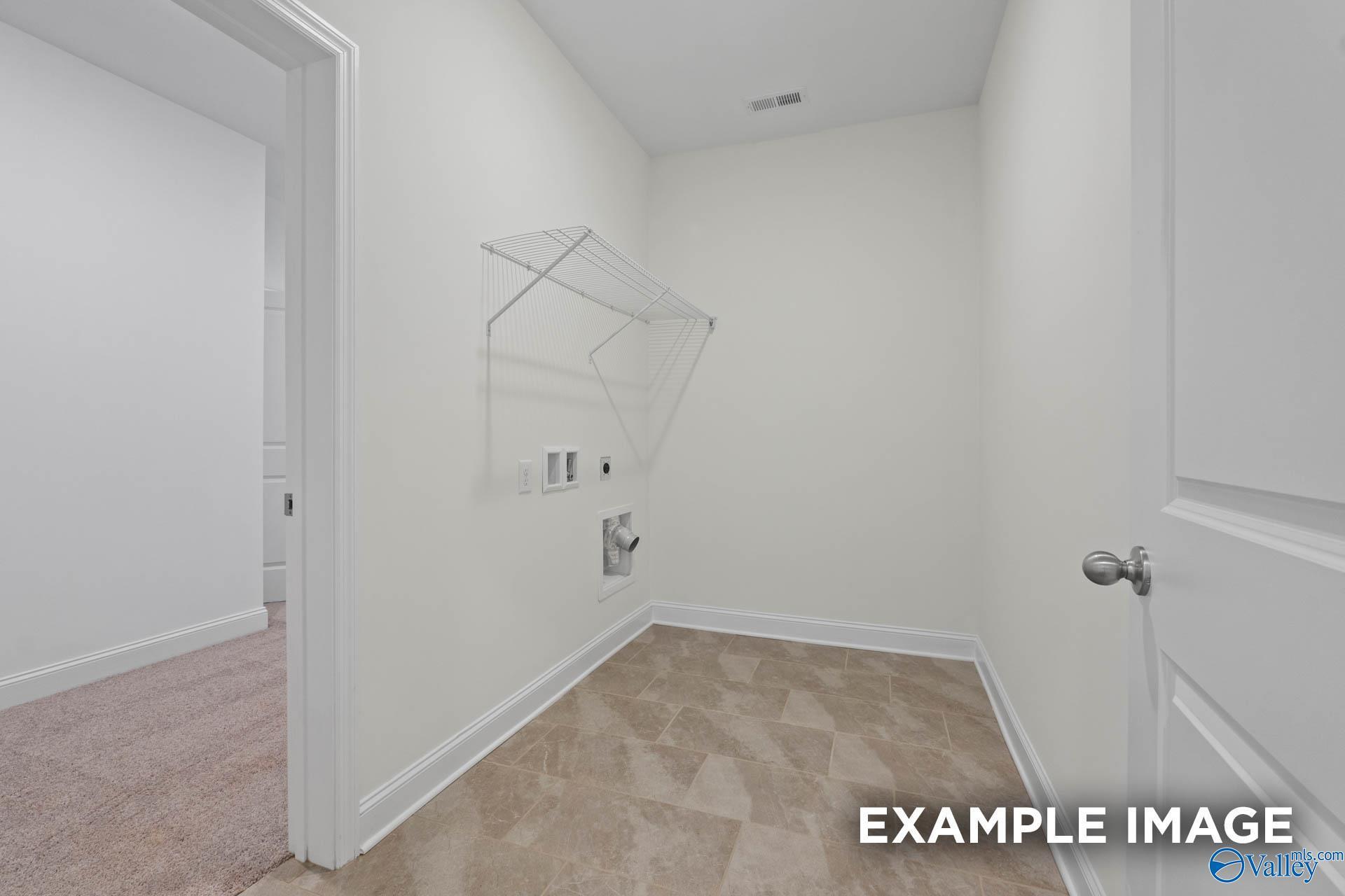 Spacious laundry room with utility sink, hanging rod and white walls in Davidson Homes The Rockford C, Madison, Alabama