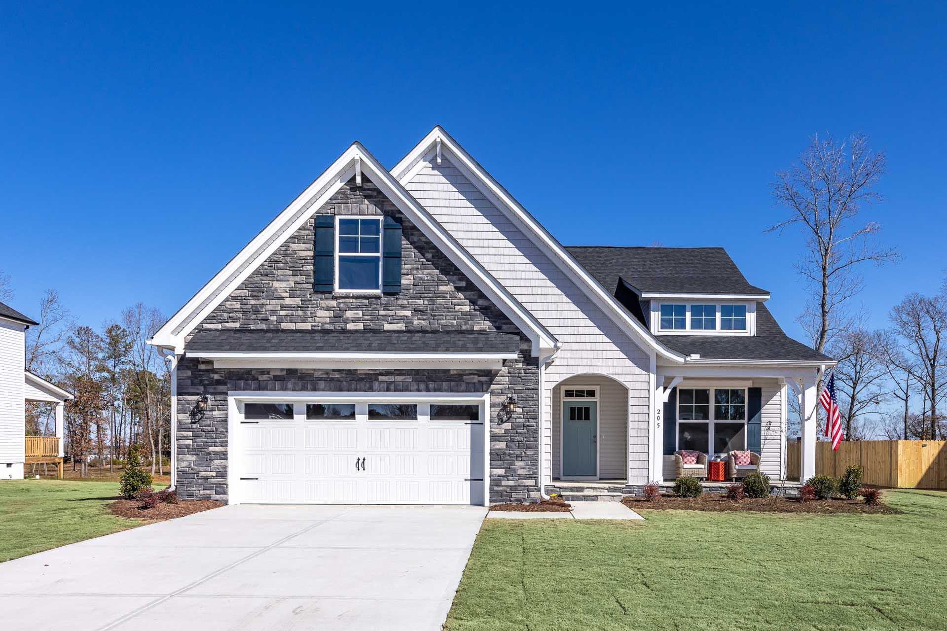 Craftsman-style home exterior at Bentwinds in Fuquay-Varina NC with stone accents, covered porch, and garage