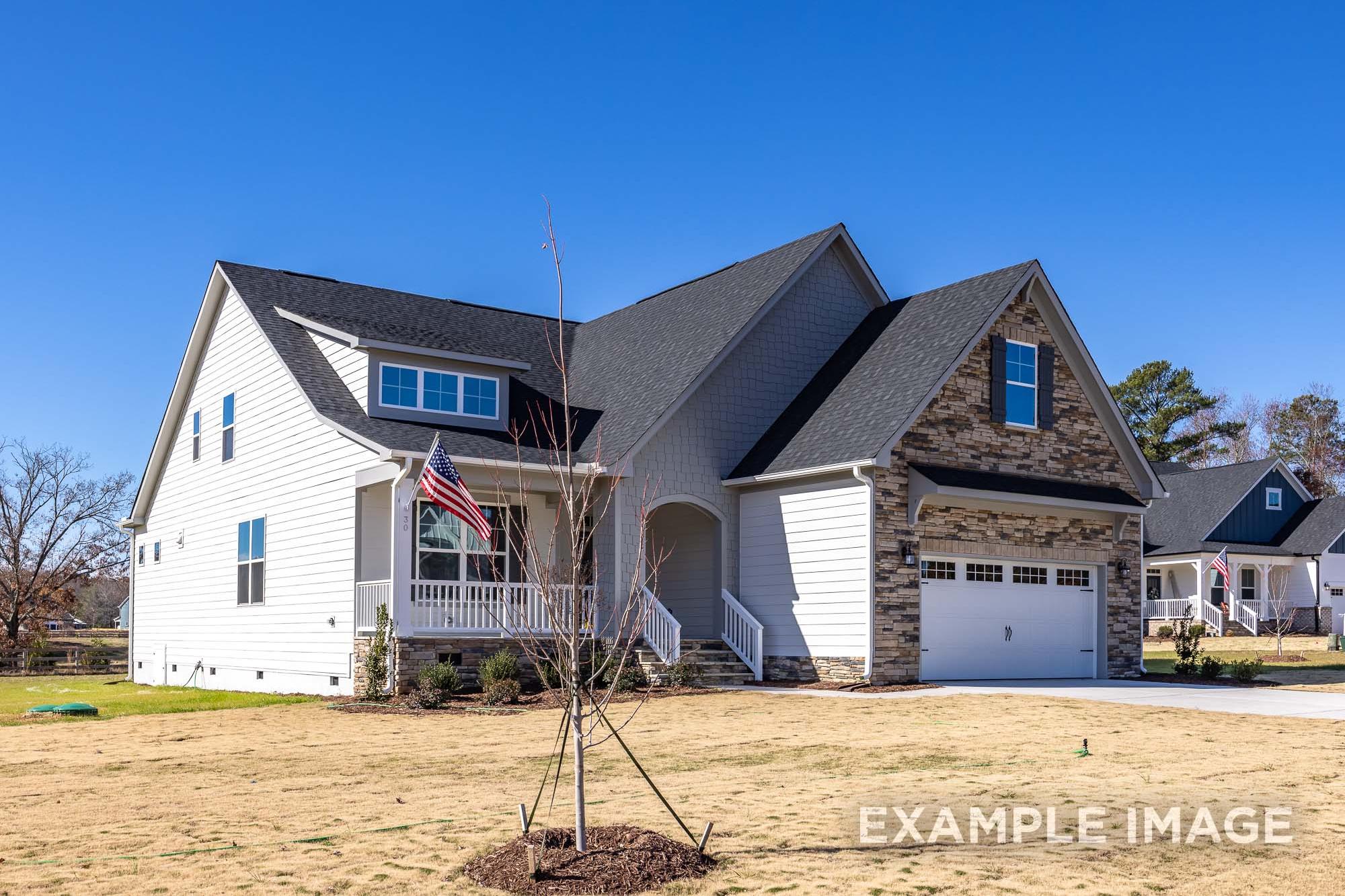 Two-story Cypress B II home elevation with white siding, stone accents, two-car garage, and front porch in Angier, NC