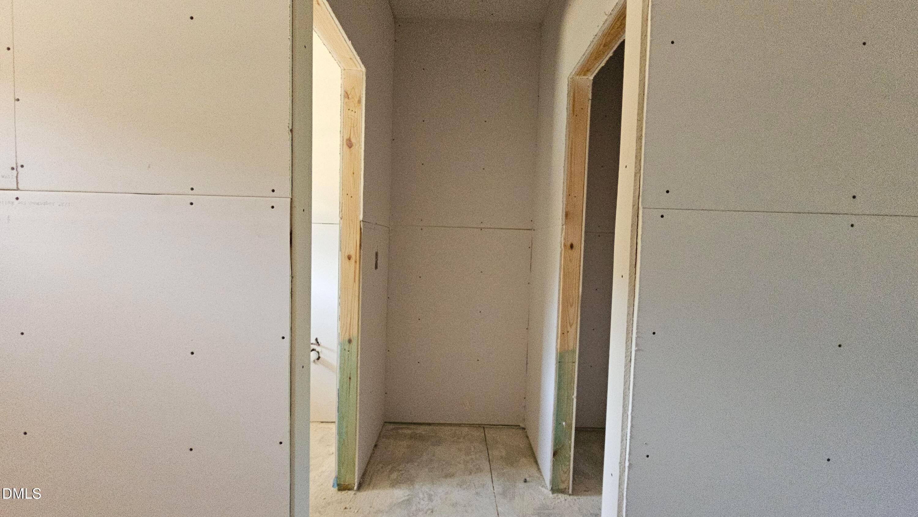 Unfinished drywall and wooden door frames in The Graham Interior floor plan at Springvale, Fuquay-Varina, North Carolina.