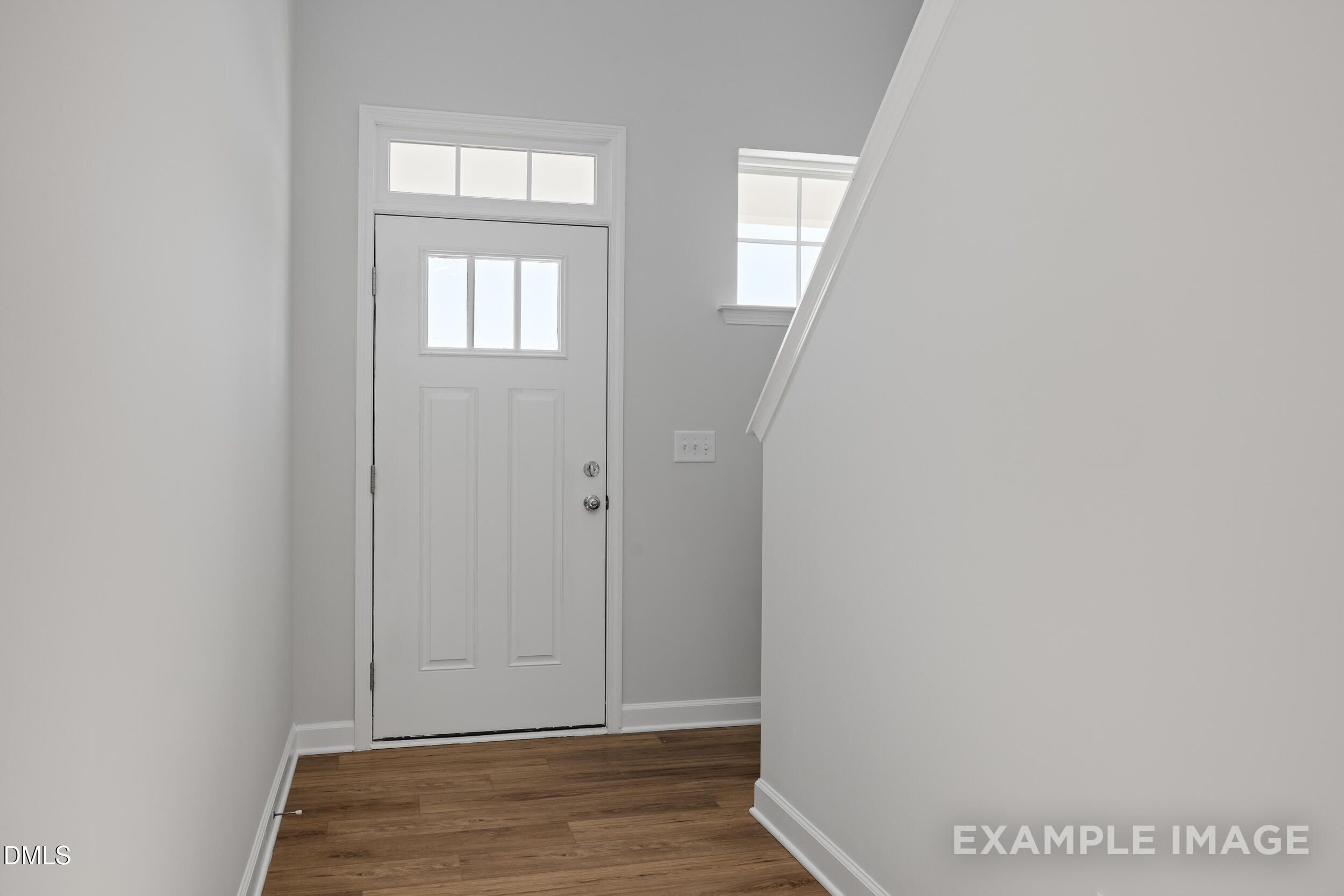 Bright entryway with white front door and wood-style flooring in The Gavin A floor plan, Gregory Village, Lillington, NC.
