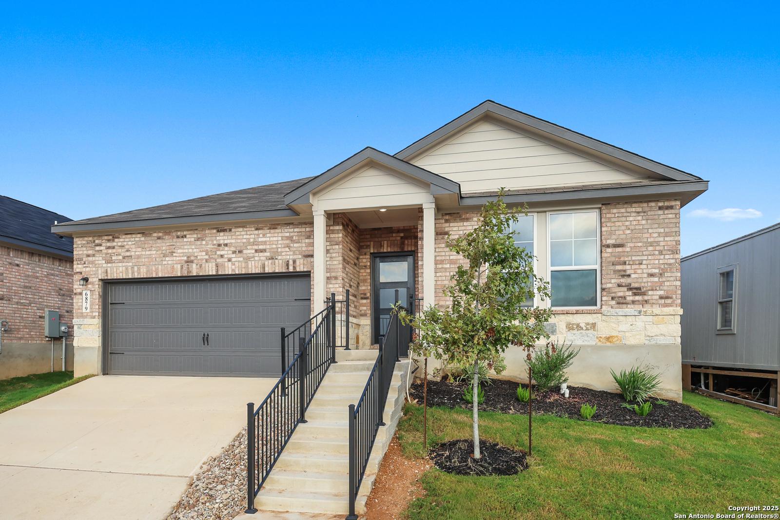 Modern single-story brick home with 2-car garage, covered entry porch, and landscaped front yard in Comanche Ridge, San Antonio, Texas