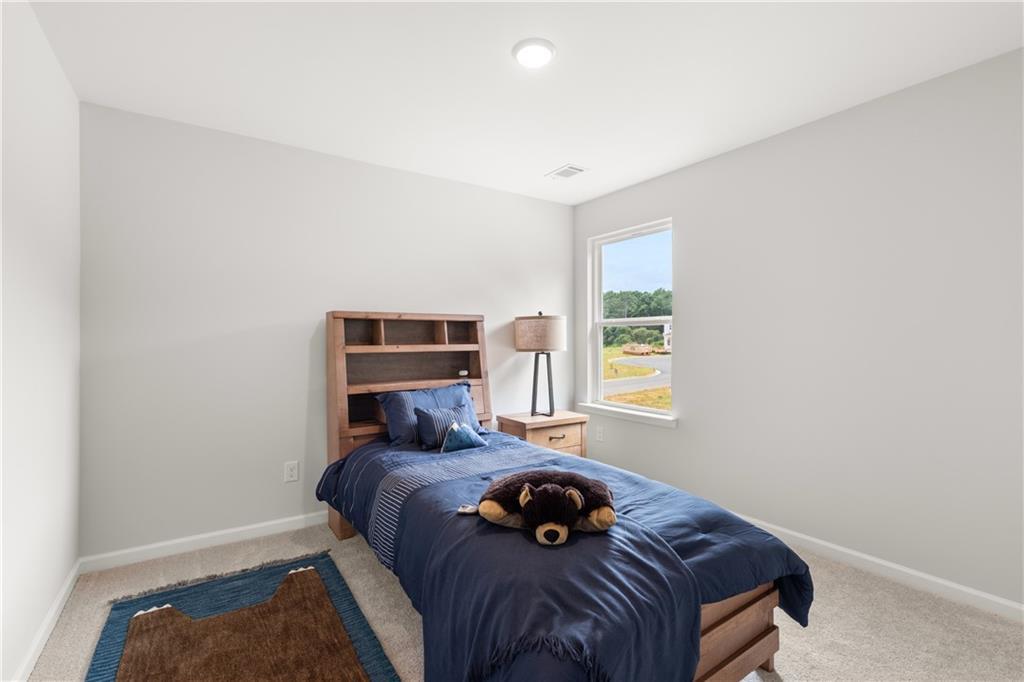 Cozy secondary bedroom with plush carpet in The Sinclair B floor plan at Cedar Farms, Winder, Georgia.