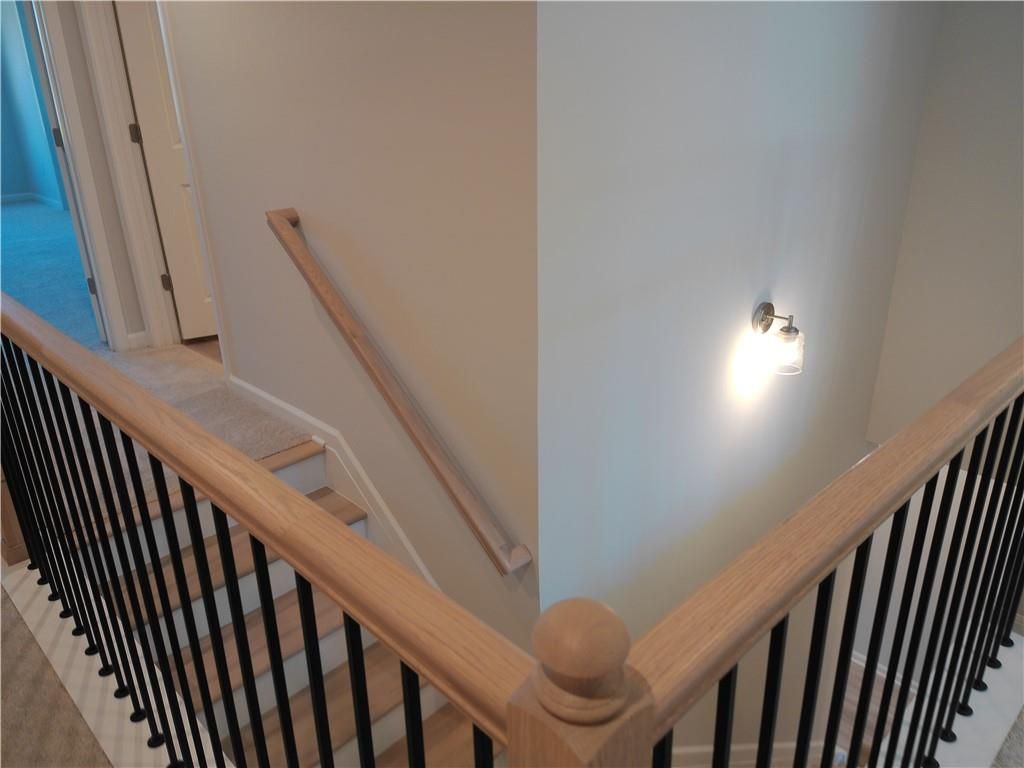Elegant oak staircase with black wrought iron railings in 2-story The Marion C home, Winder, Georgia